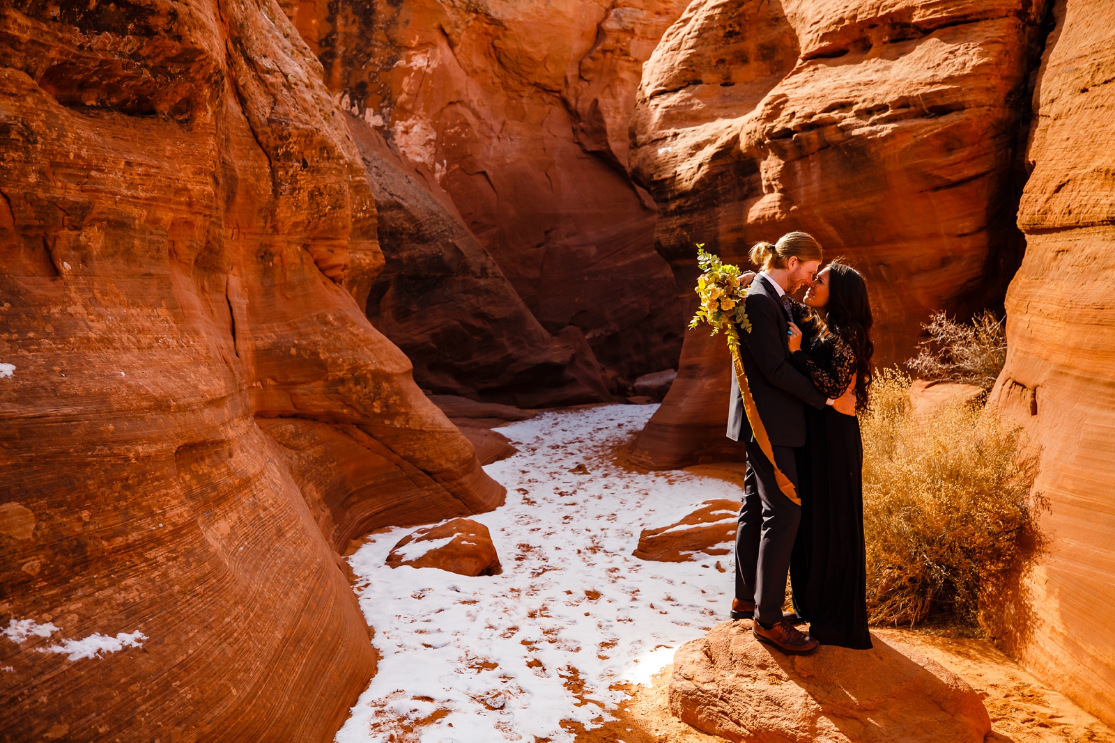 Couple cuddling in a snow slot canyon