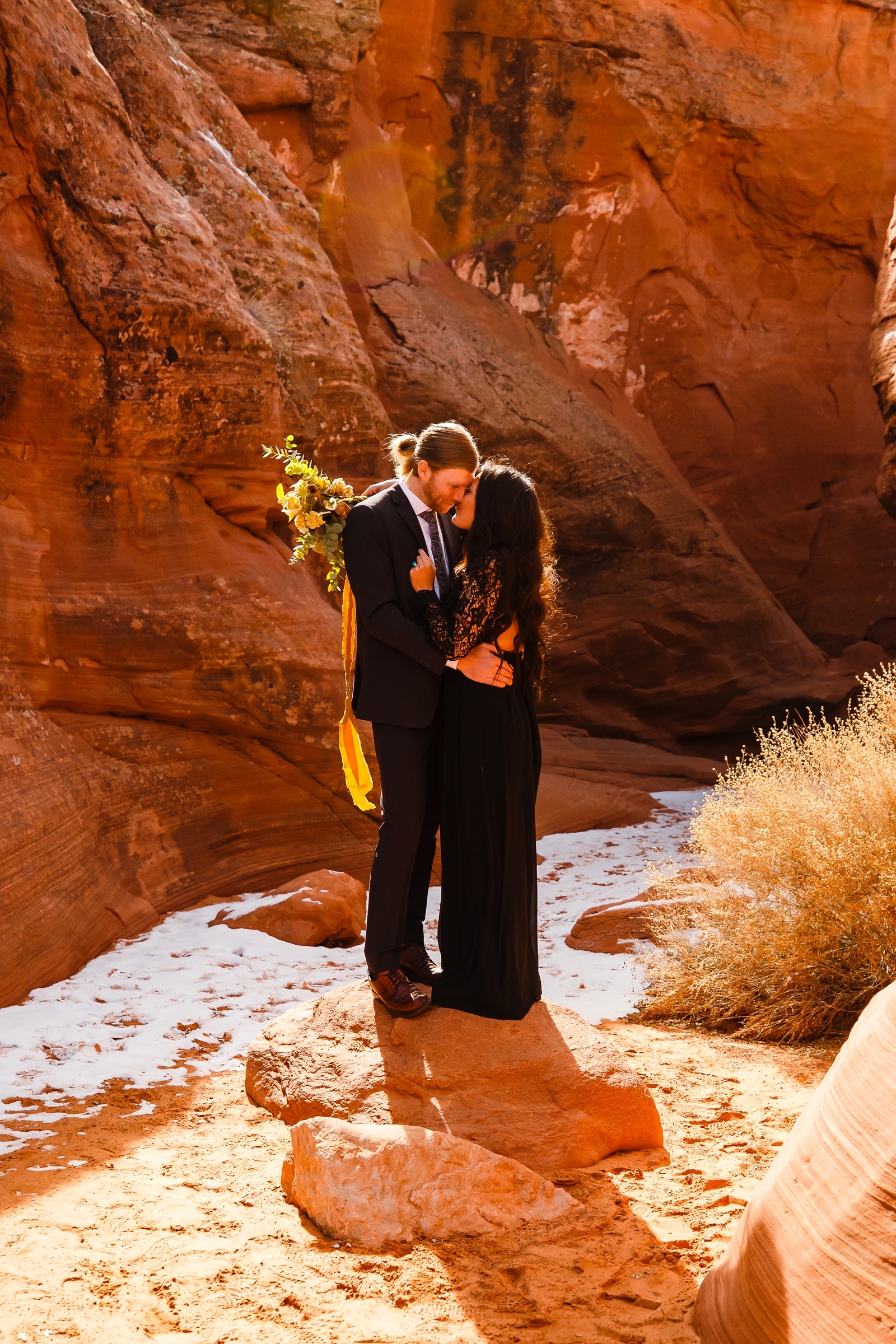 Couple kissing in a snowy slot canyon.