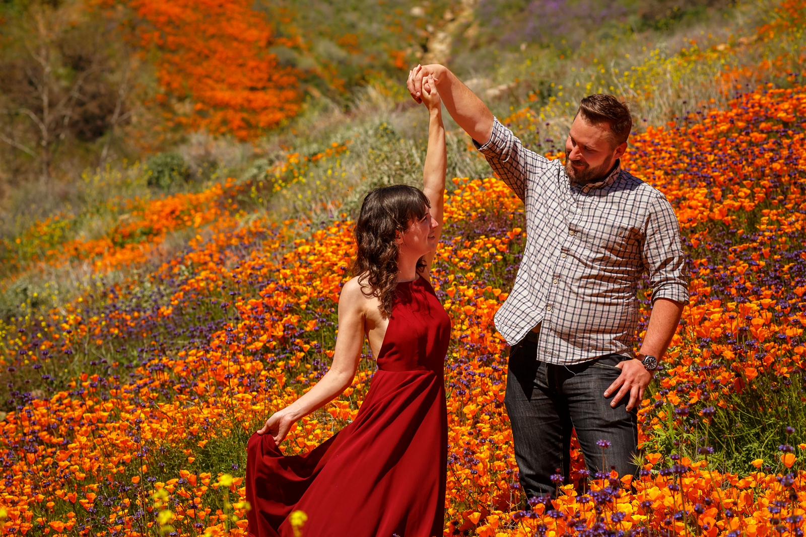 Engaged couple dancing in wildflower fields.