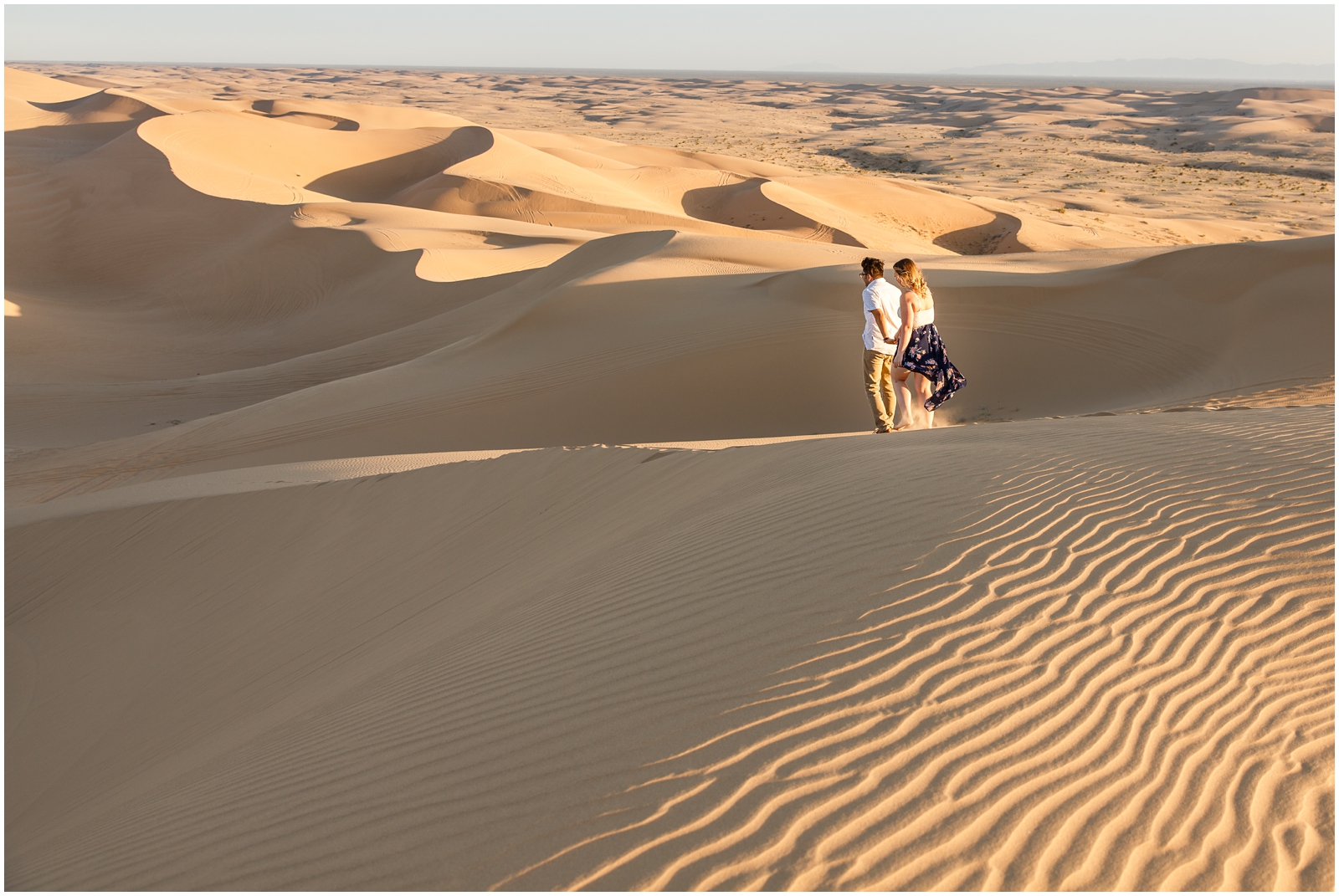 Engaged couple exploring the sand dunes.