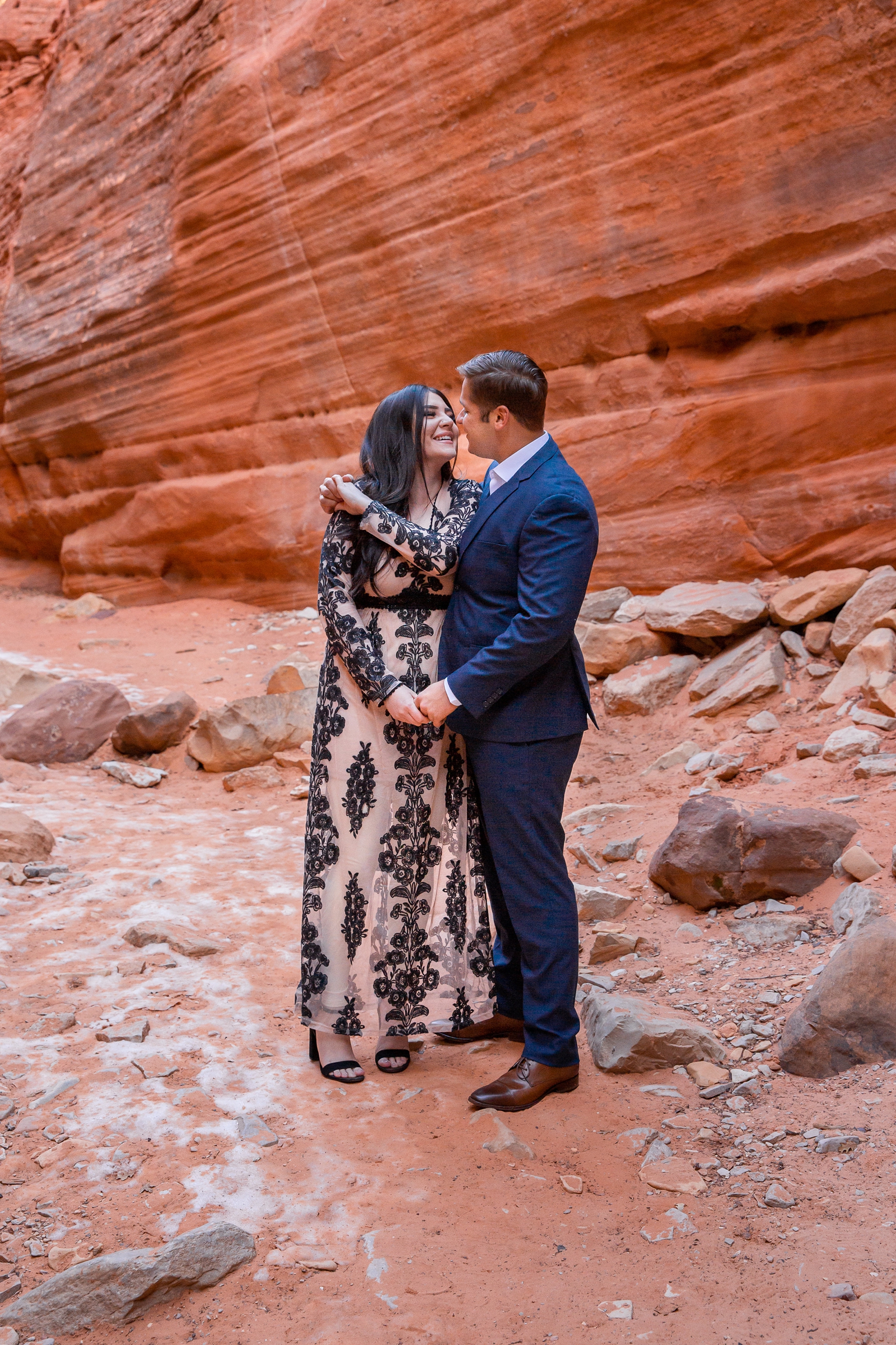Giddy engaged couple in a red rock slot canyon.