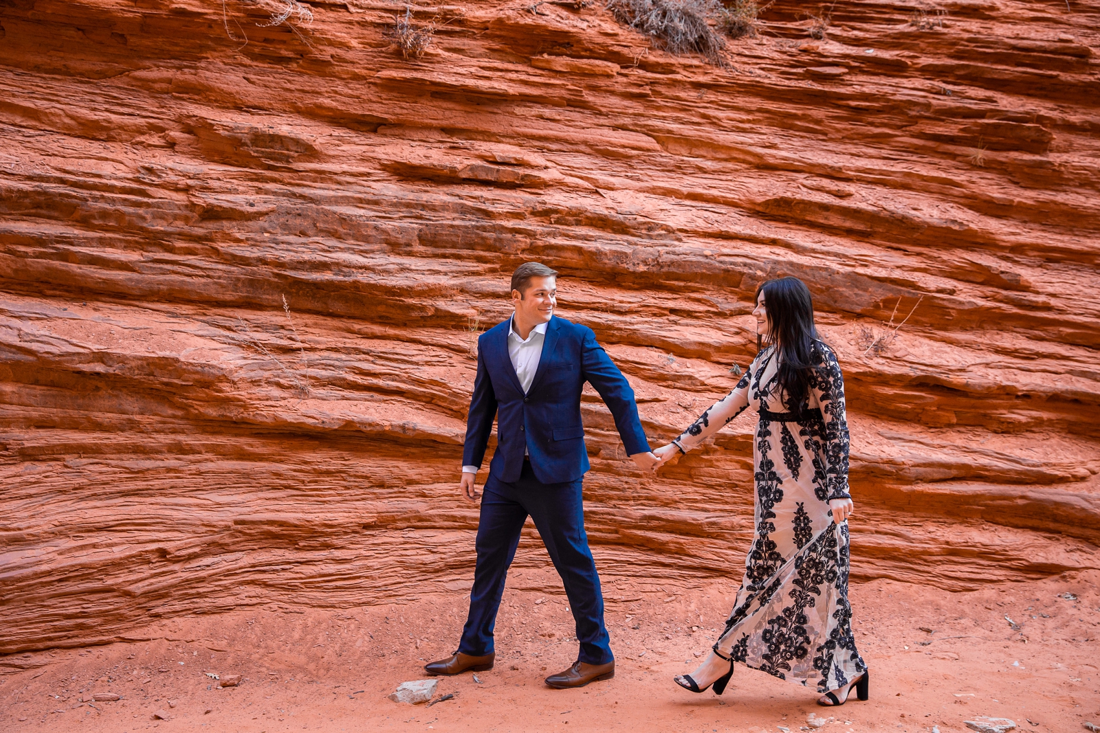 Engaged couple hiking in a Utah slot canyon.