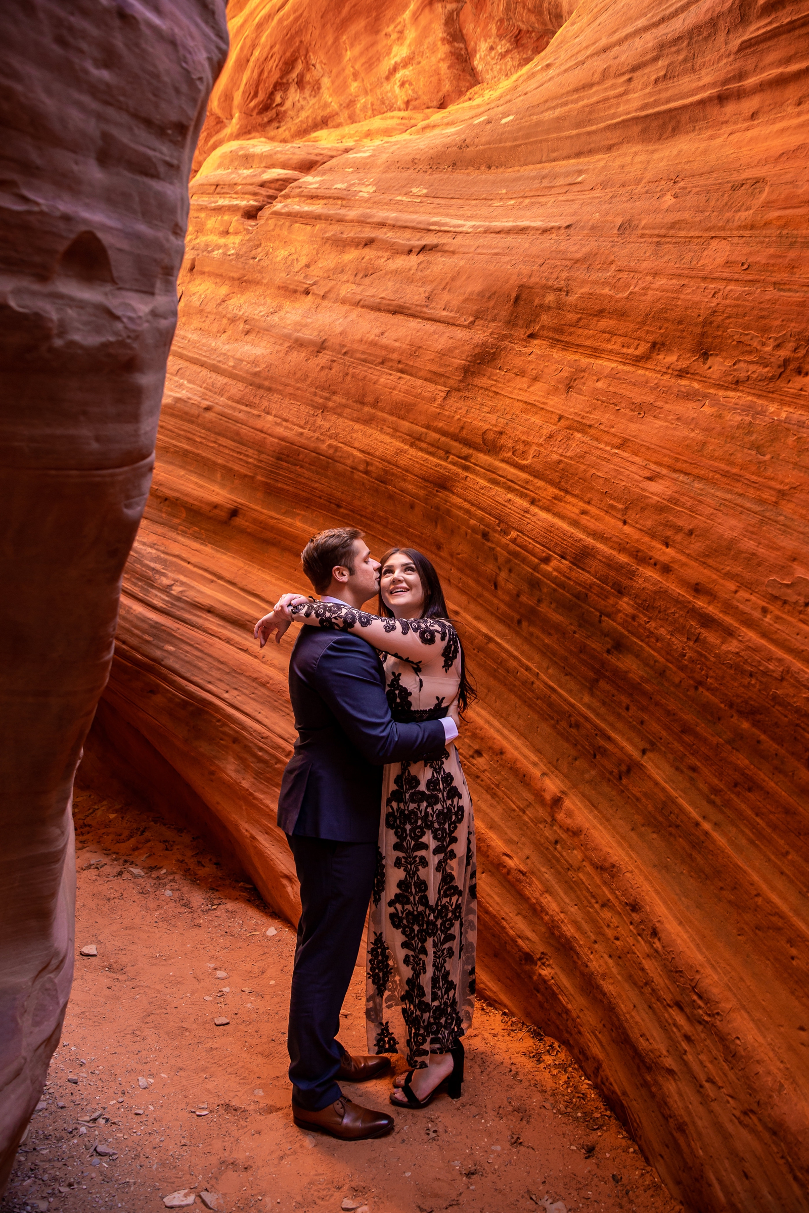 Adorable engaged couple in a glowing Utah slot canyon.