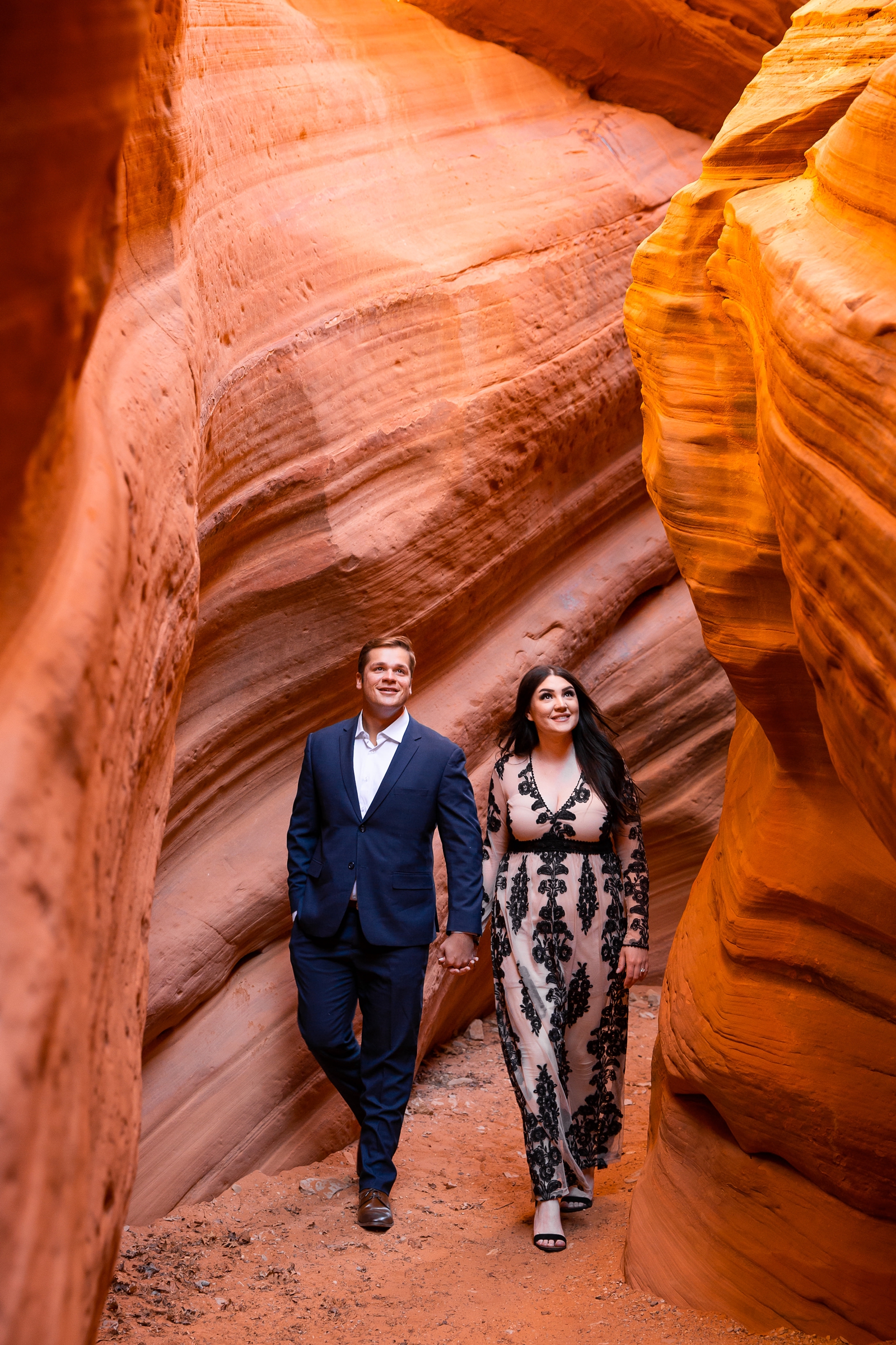 Engaged couple hiking in a Southern Utah slot canyon.