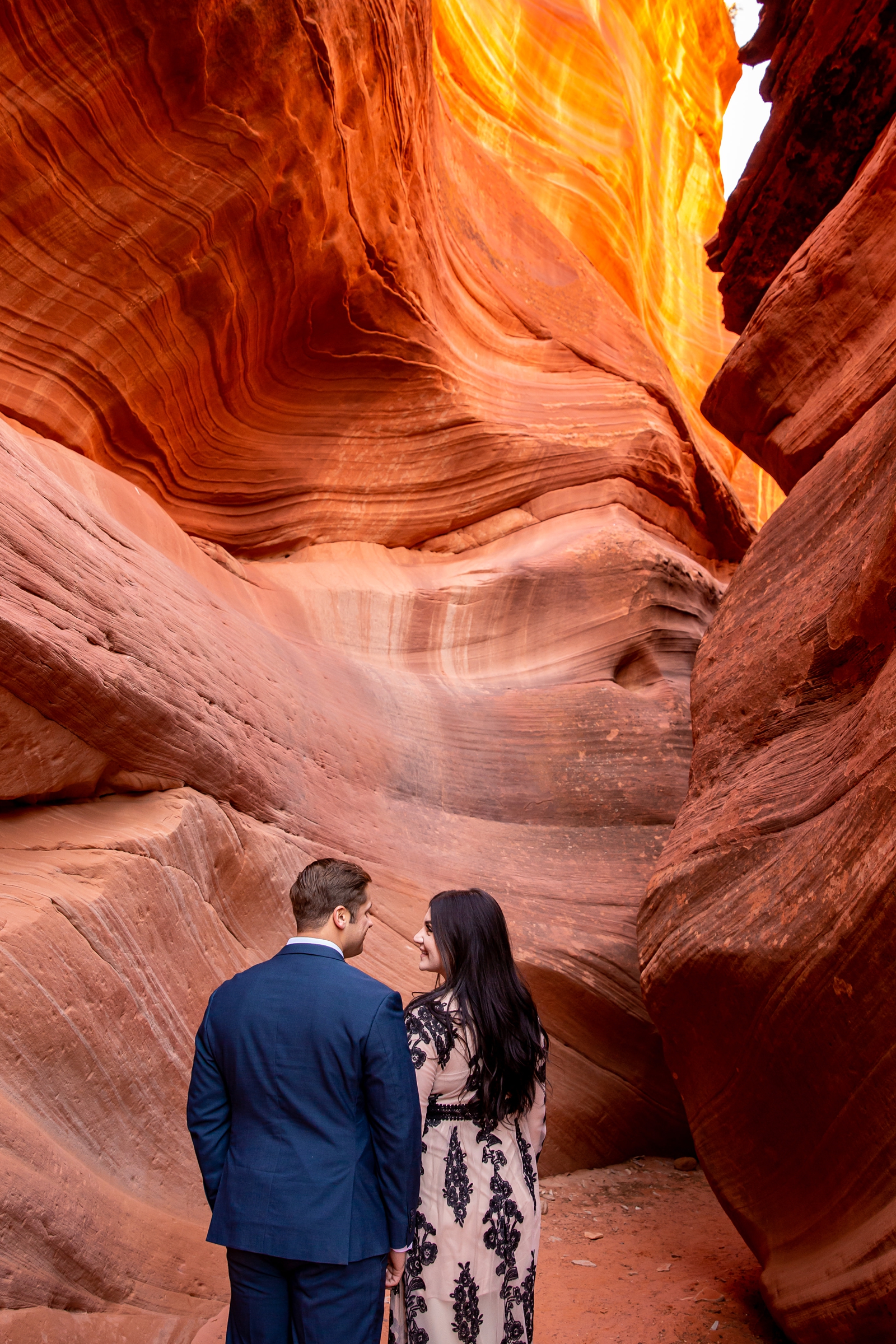 Couple lovingly looking into each others eyes in a slot canyon.
