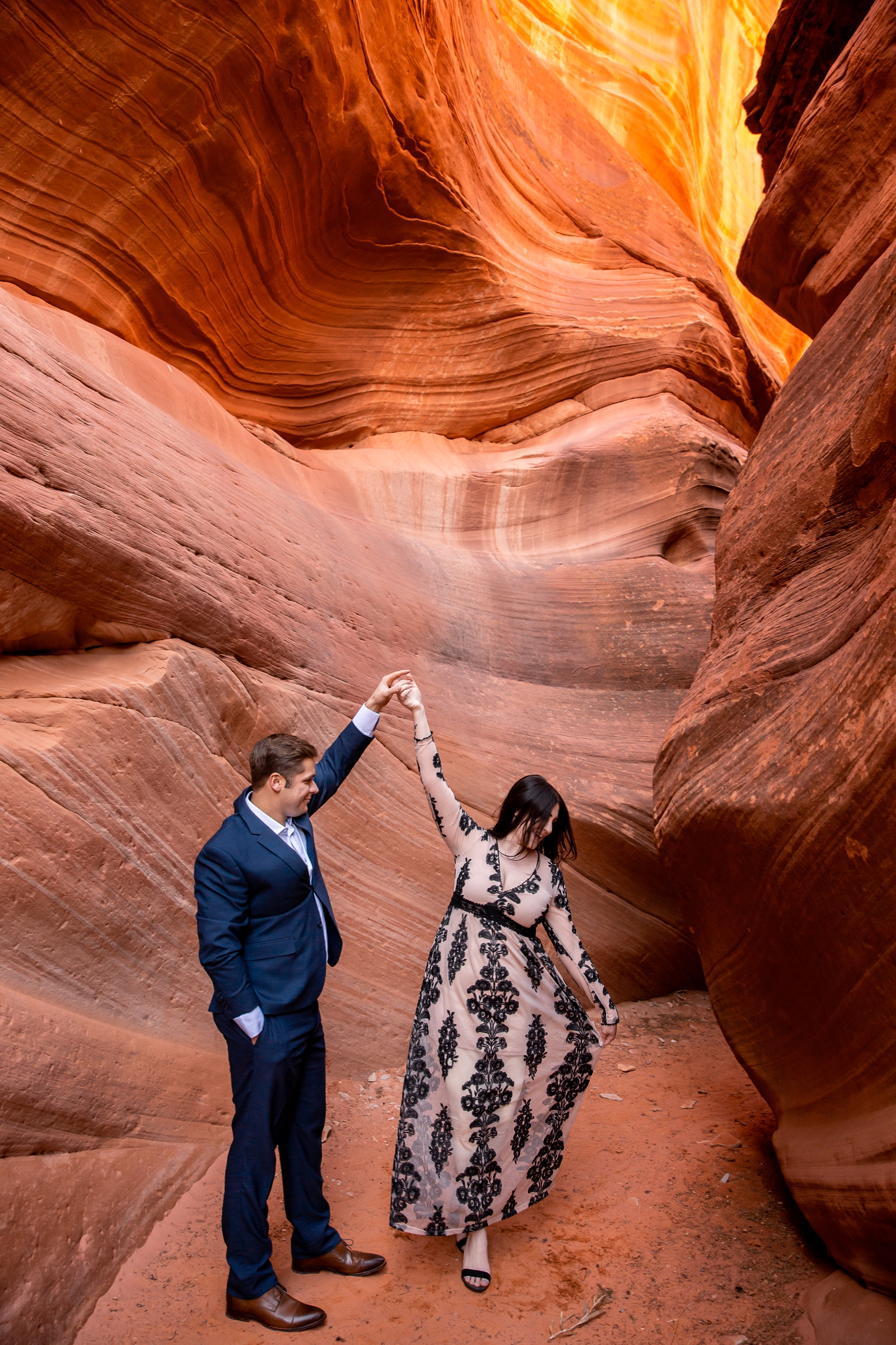 Engaged couple dancing in a Utah slot canyon.