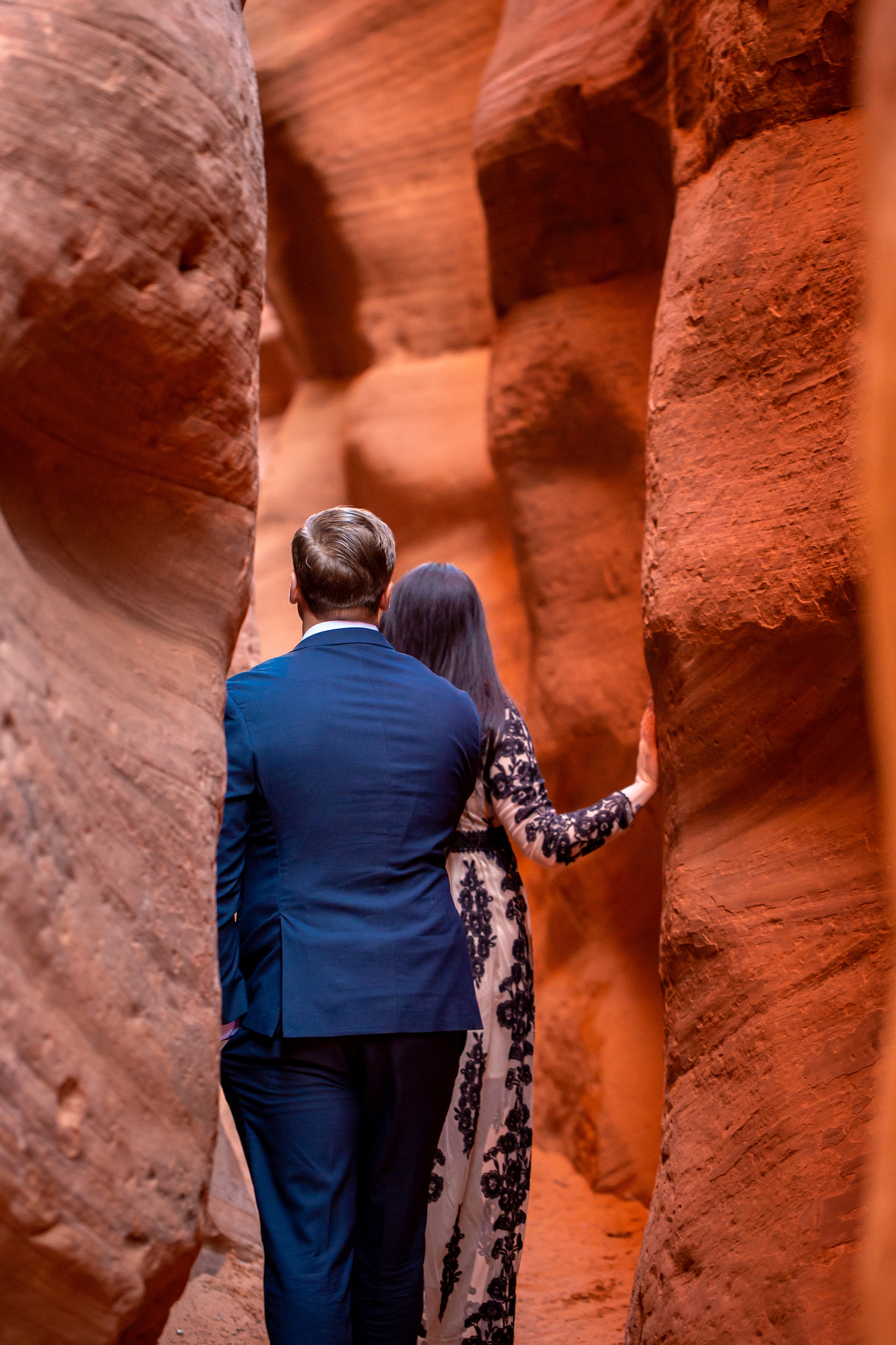 Engaged couple hiking in a Utah slot canyon.