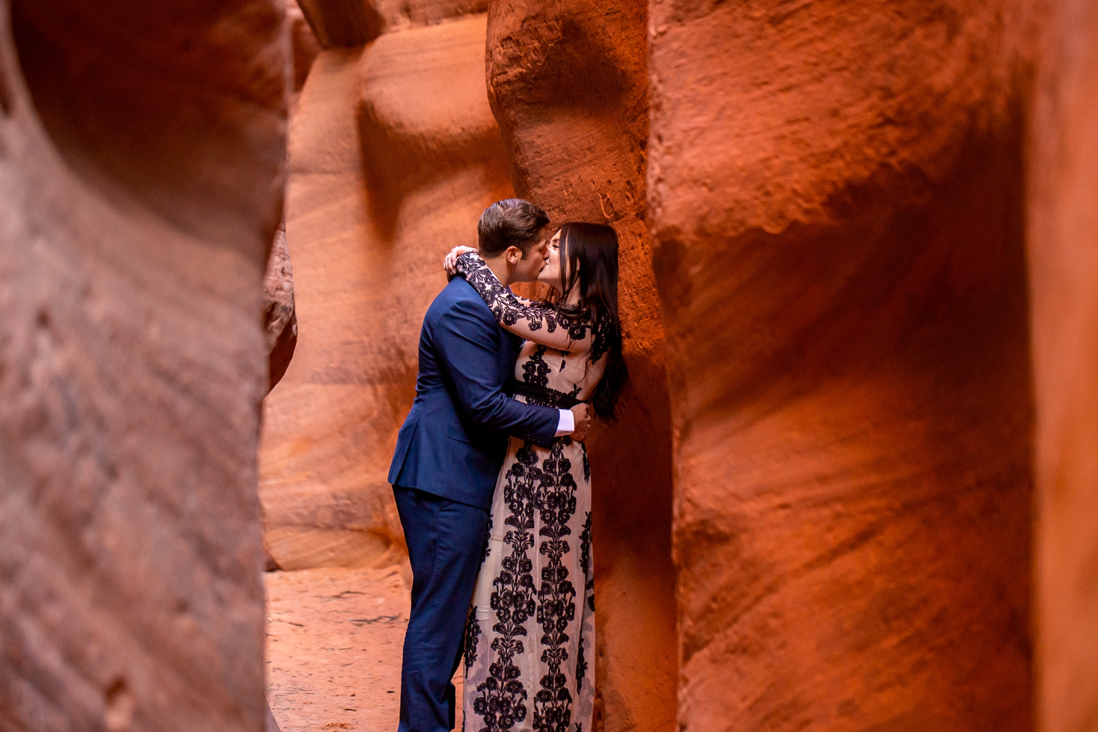 Dreamy couple kissing in a red rock canyon.