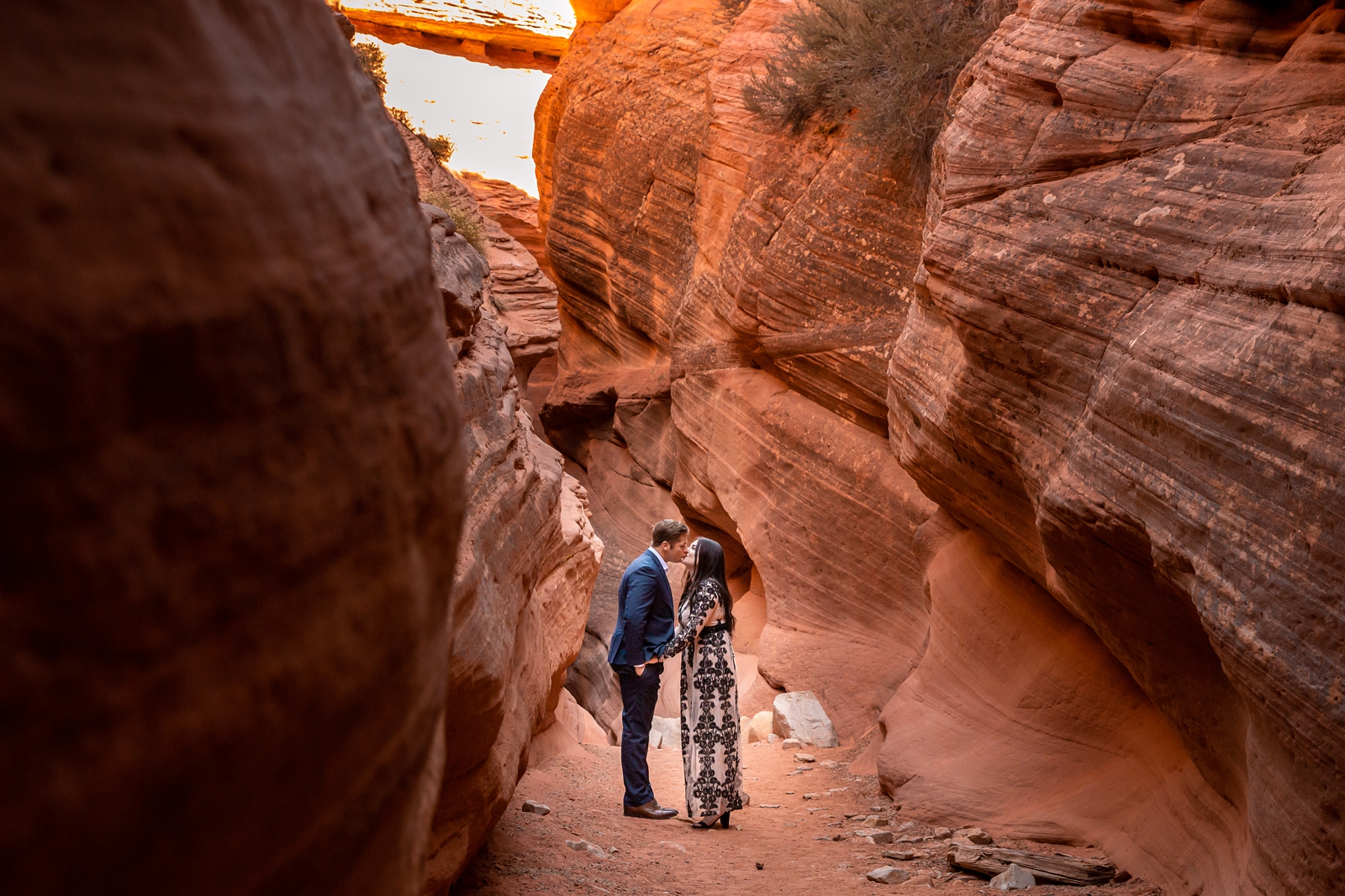 Engaged couple cuddling to keep warm in a slot canyon.