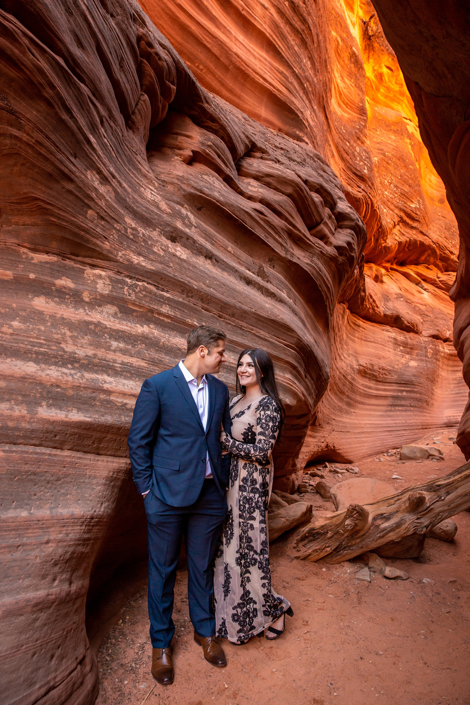 Engaged couple lovingly staring into each other's eyes in a slot canyon.