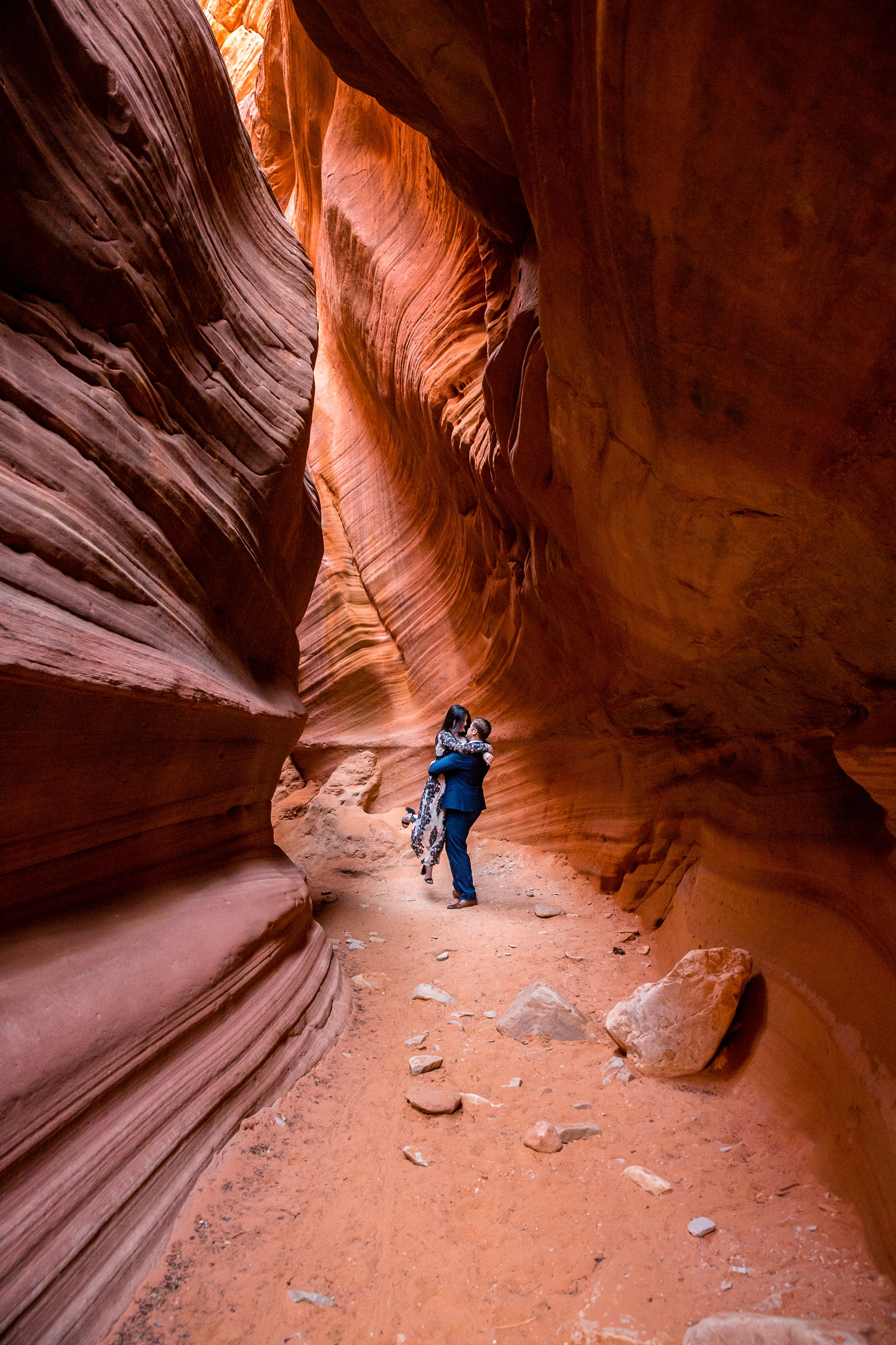 Romantic engaged couple spinning in a Utah slot canyon.