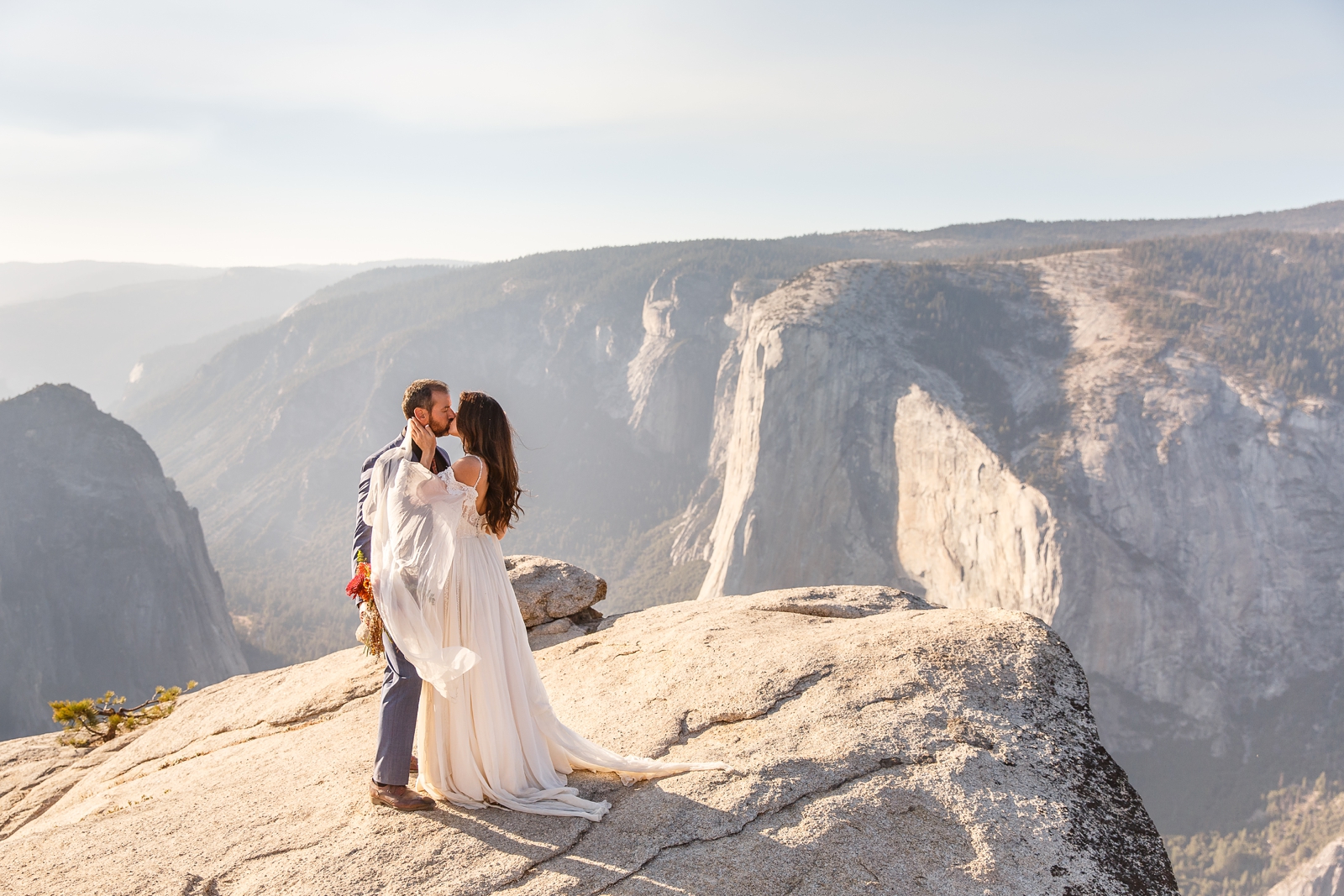 Epic wedding kiss on the side of a cliff in Yosemite. 