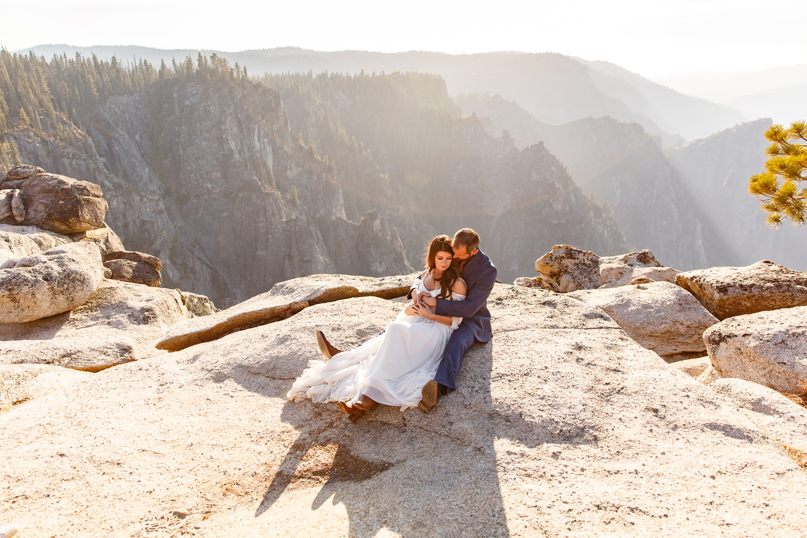 Couple cuddling on a cliff in Yosemite.