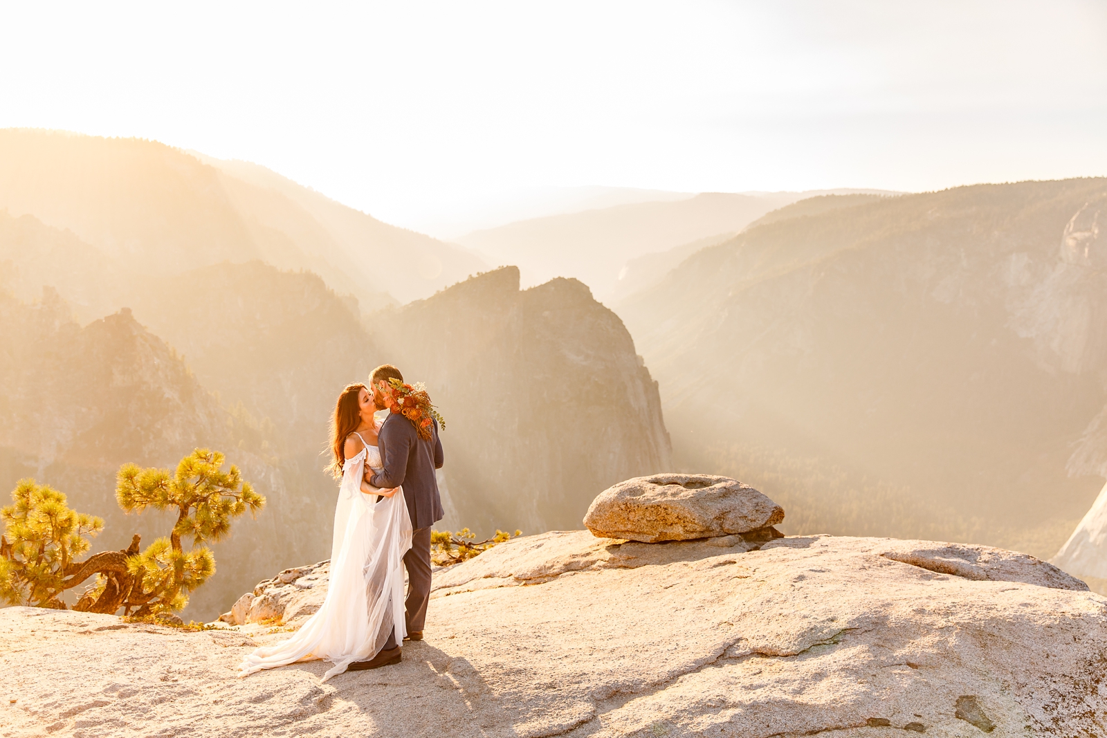 Passionate kissing bride and groom during golden hour at Taft Point Yosemite.