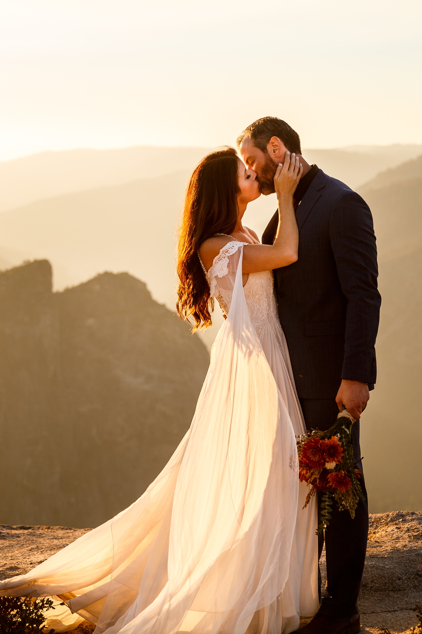Dreamy bride and groom kissing at sunset in Yosemite high country.