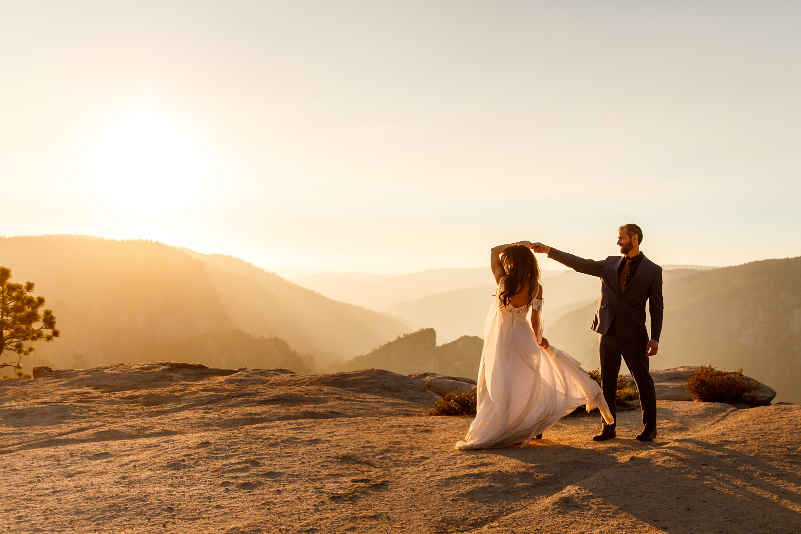 Couple dancing on a cliff at sunset in Yosemite.