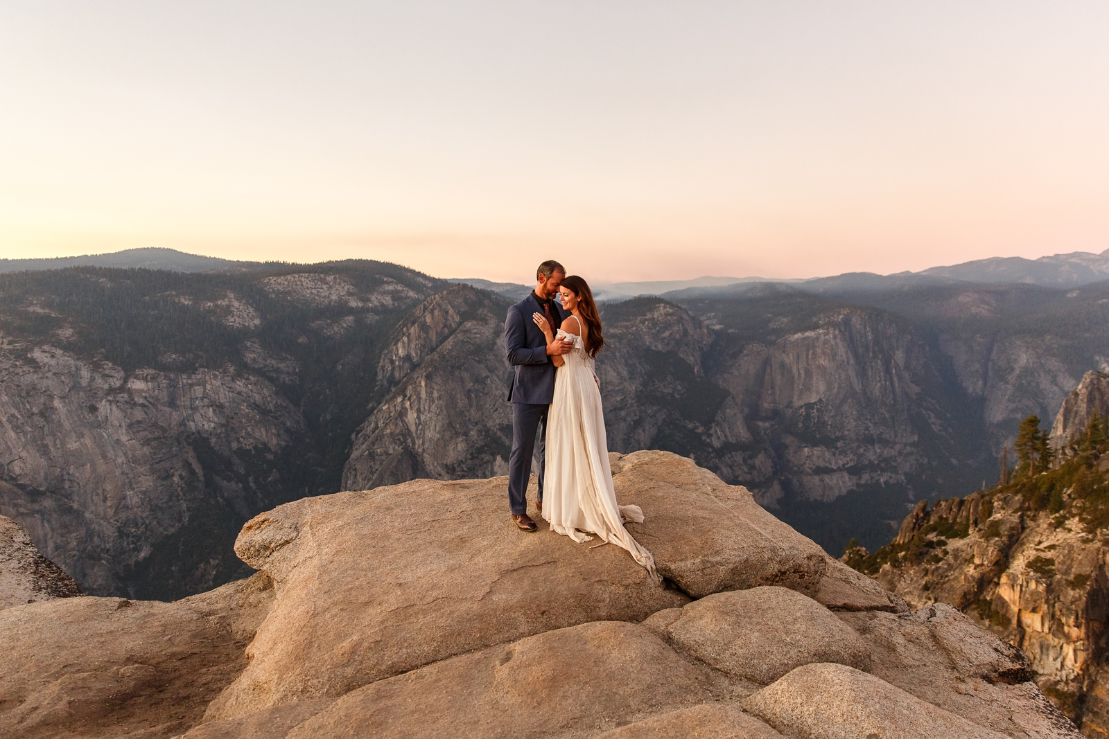 This just married couple is intimately cuddling at Taft Point in Yosemite.