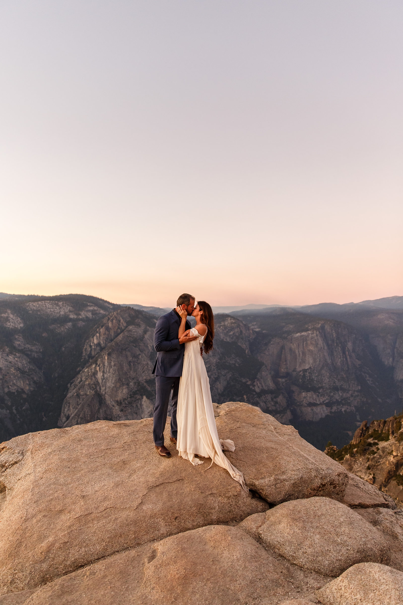 A couple gently kissing at their sunset Yosemite NP elopement.