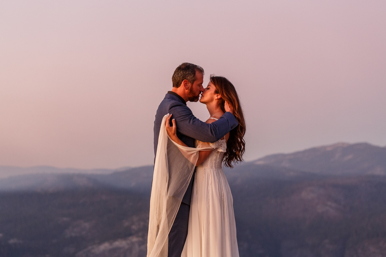 Eloping couple intimately kissing at Taft Point in Yosemite.