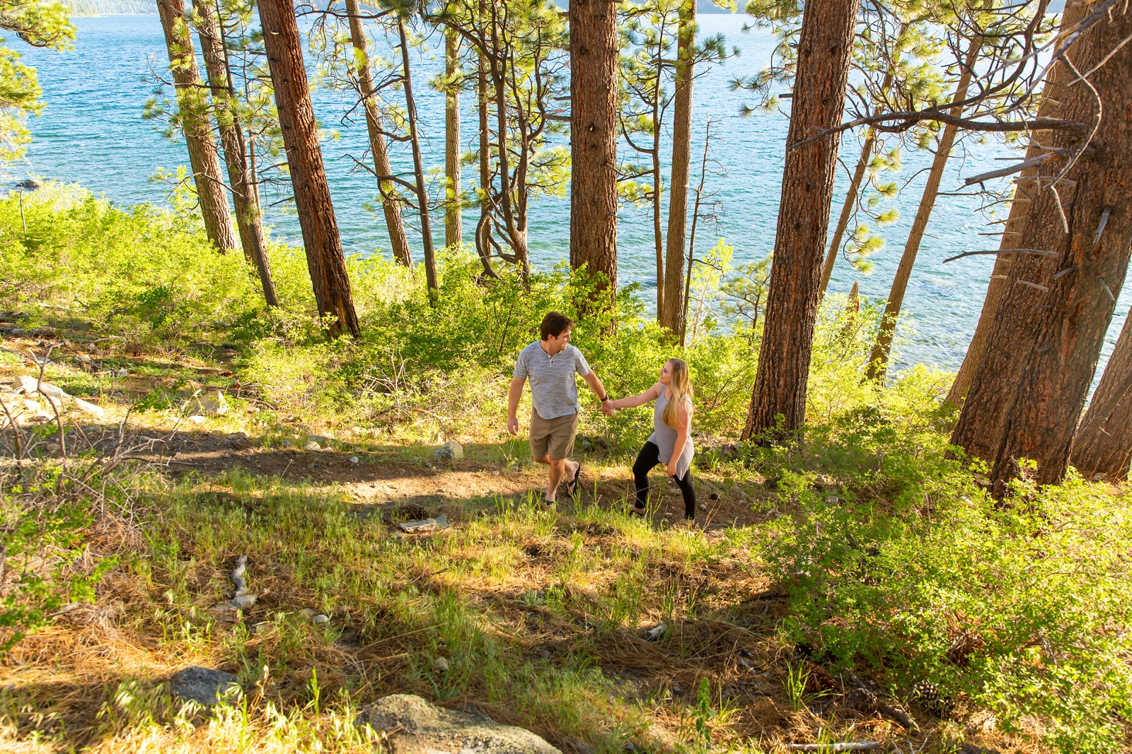 a couple walking up a hill holding hands by Lake Tahoe for their adventure session