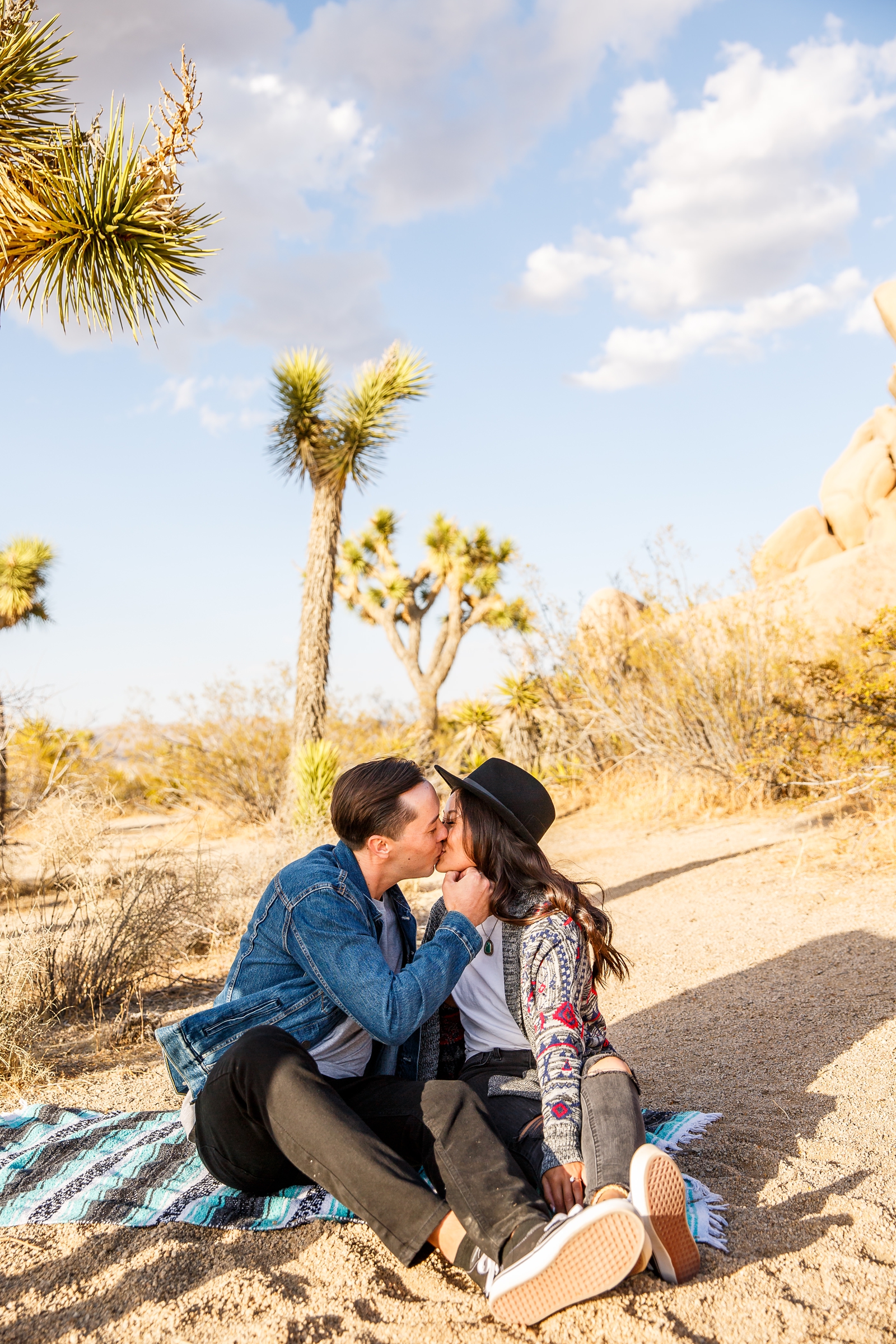 This engaged couple kissed on a blanket in Joshua Tree. 