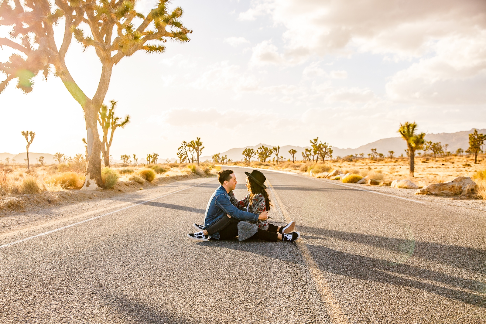 Dreamy engaged couple in the middle of the road during golden hour in Joshua Tree.