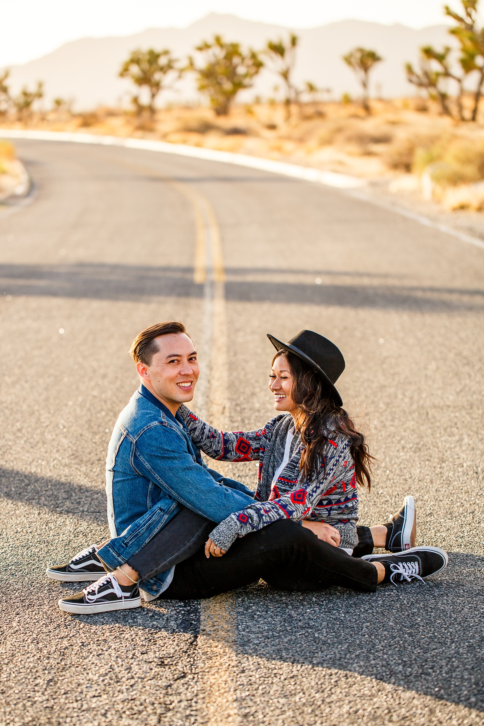 Engaged couple laughing in the road in Joshua Tree National Park.
