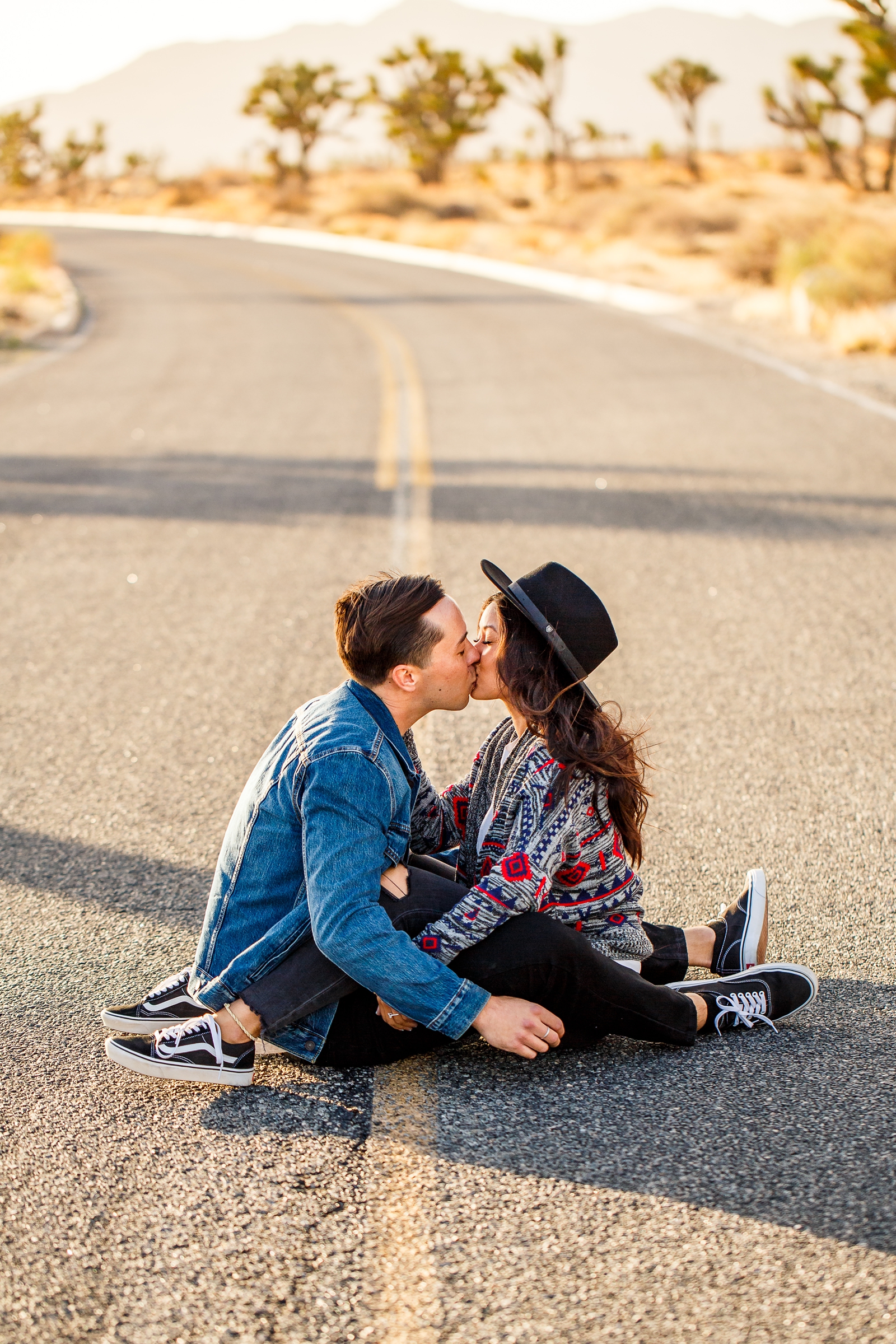 Engaged couple kissing in the road at their Joshua Tree National Park engagement session.