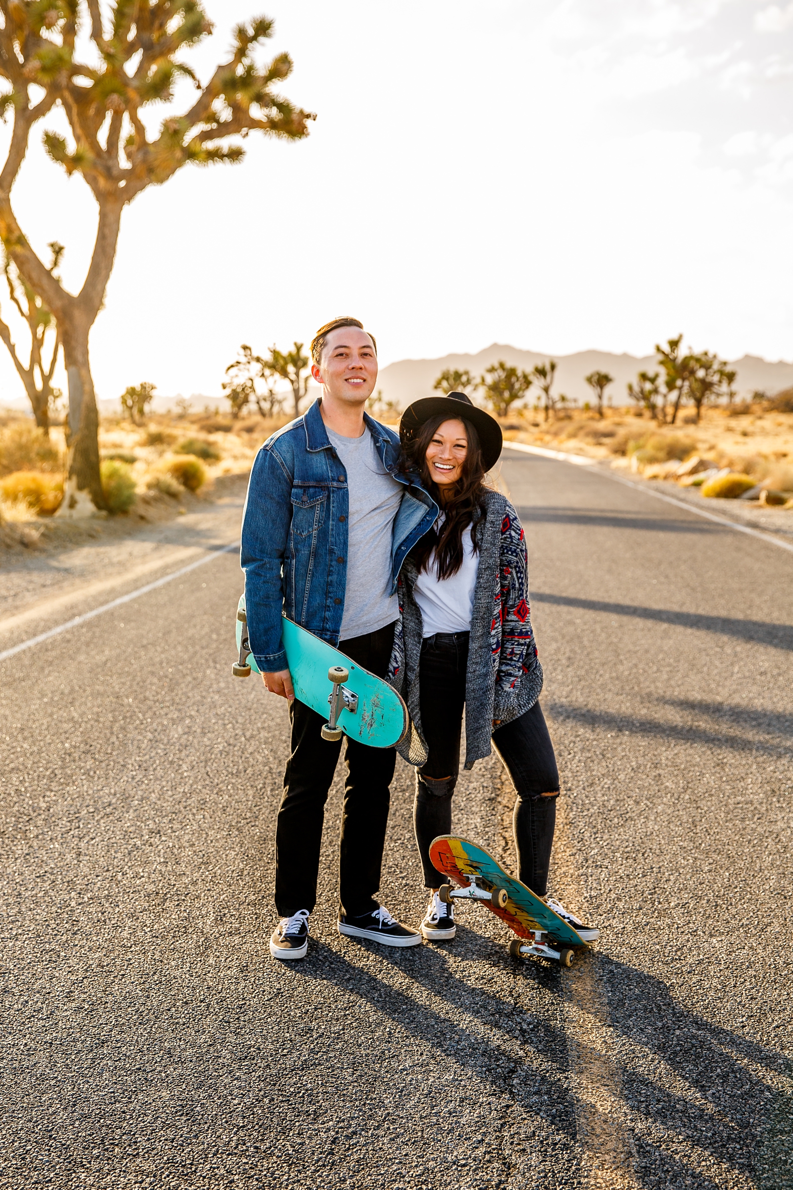 Adorable engaged couple about to skateboard in Joshua Tree NP. 