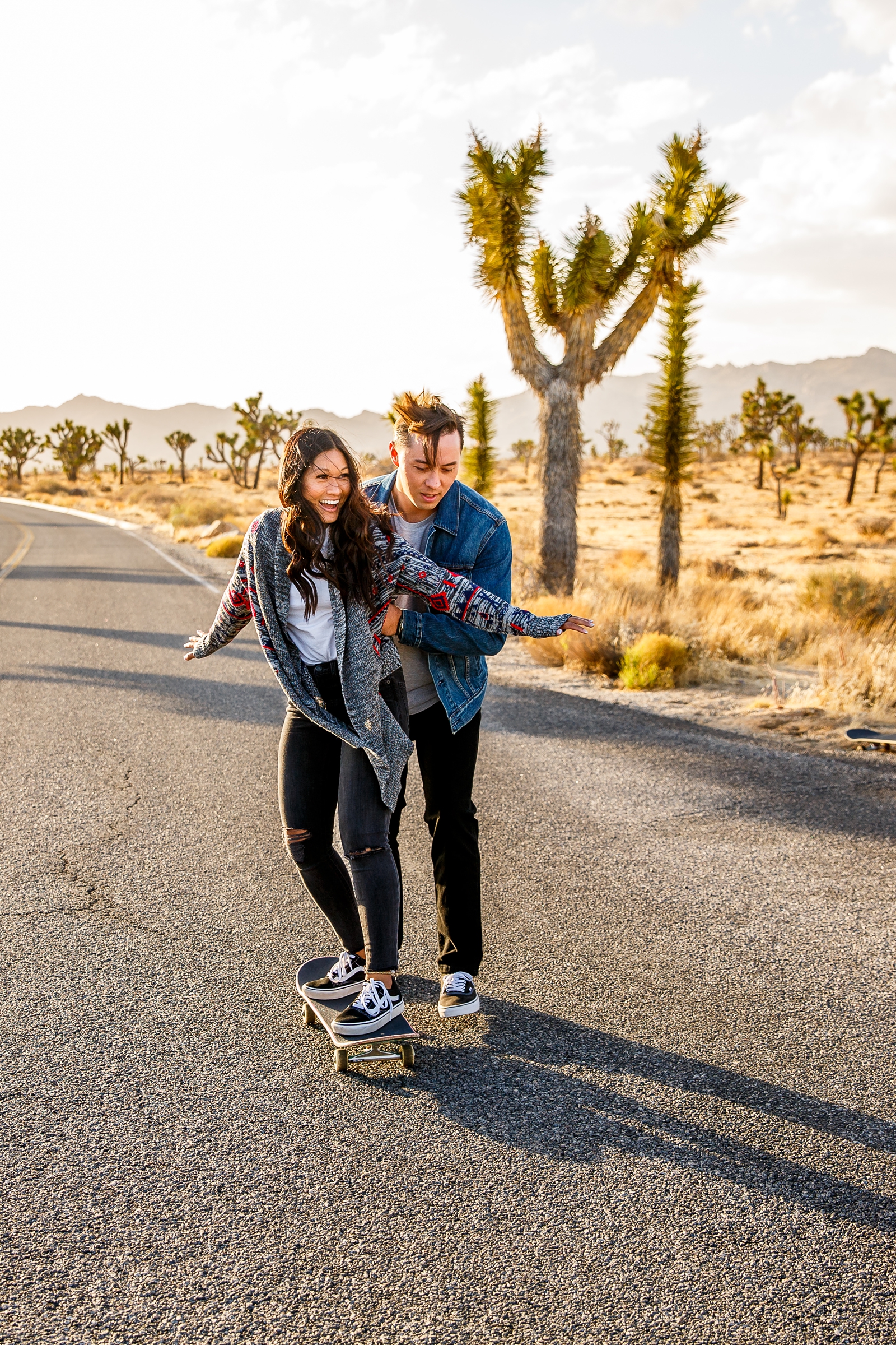 Couple in love skateboarding at their Joshua Tree engagement session.