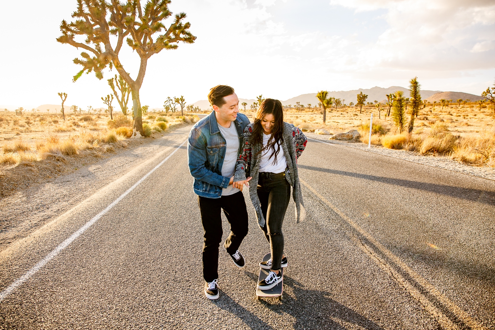 Cute engaged couple skateboarding at golden hour in Joshua Tree. 