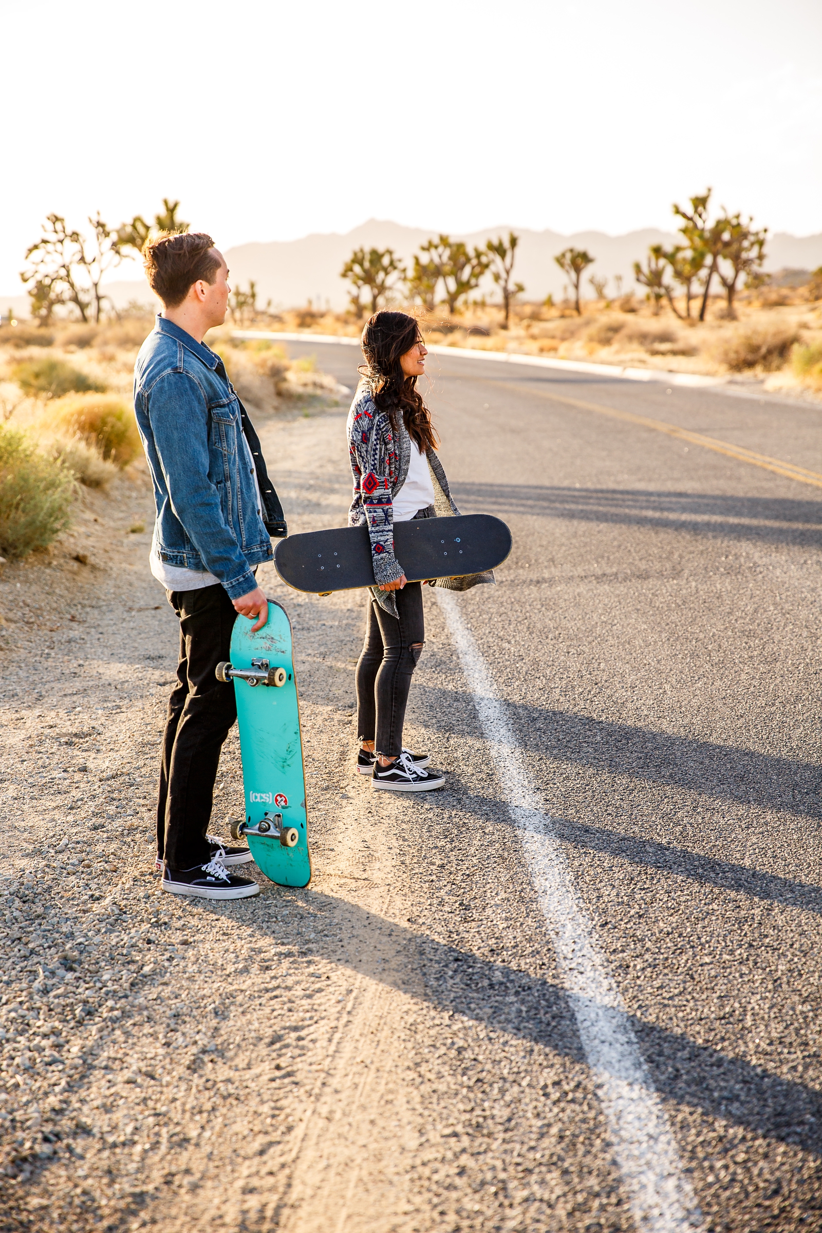 Engaged couple waiting to skateboard in Joshua Tree NP.