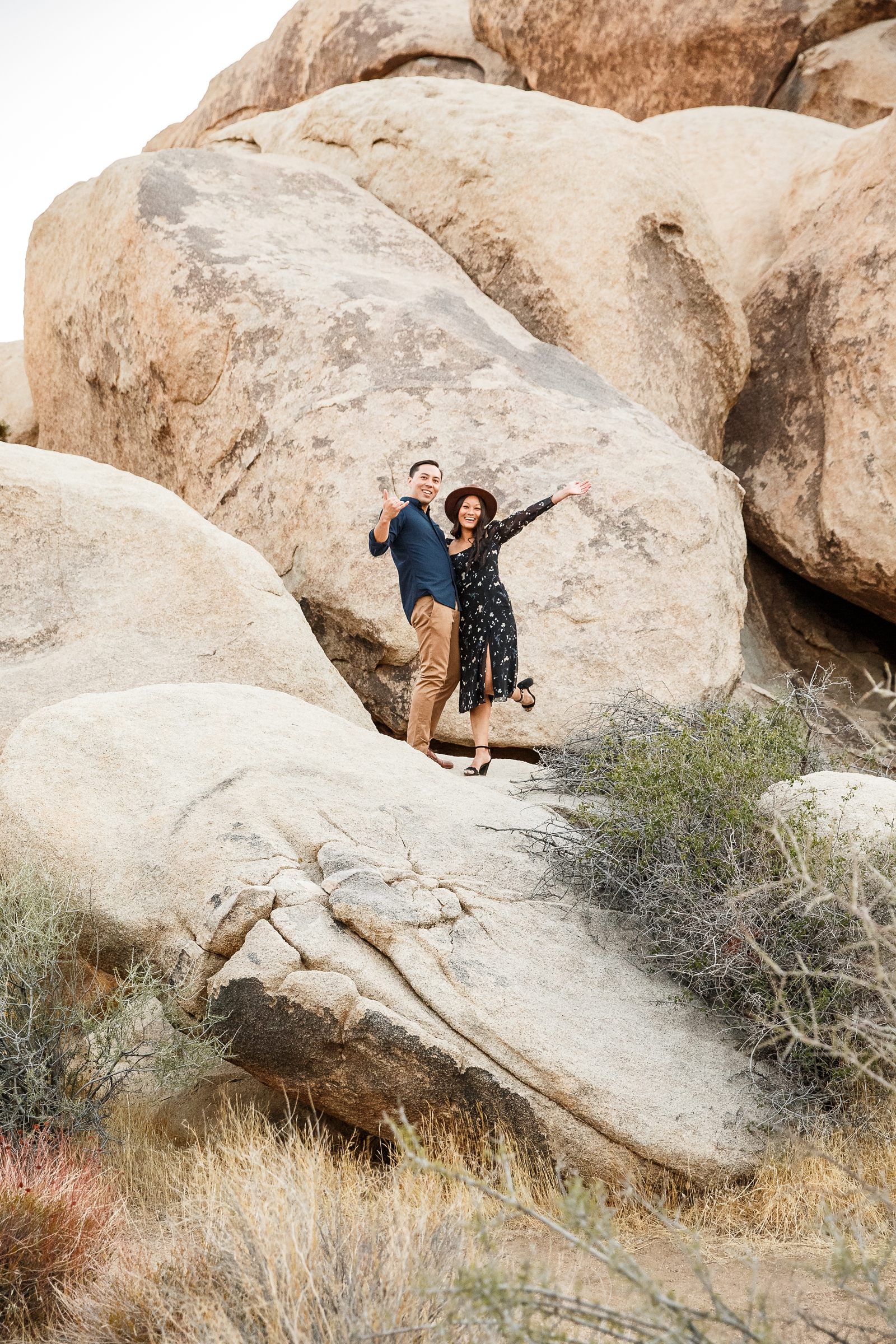 Engaged couple having fun on the rocks in Joshua Tree National Park.