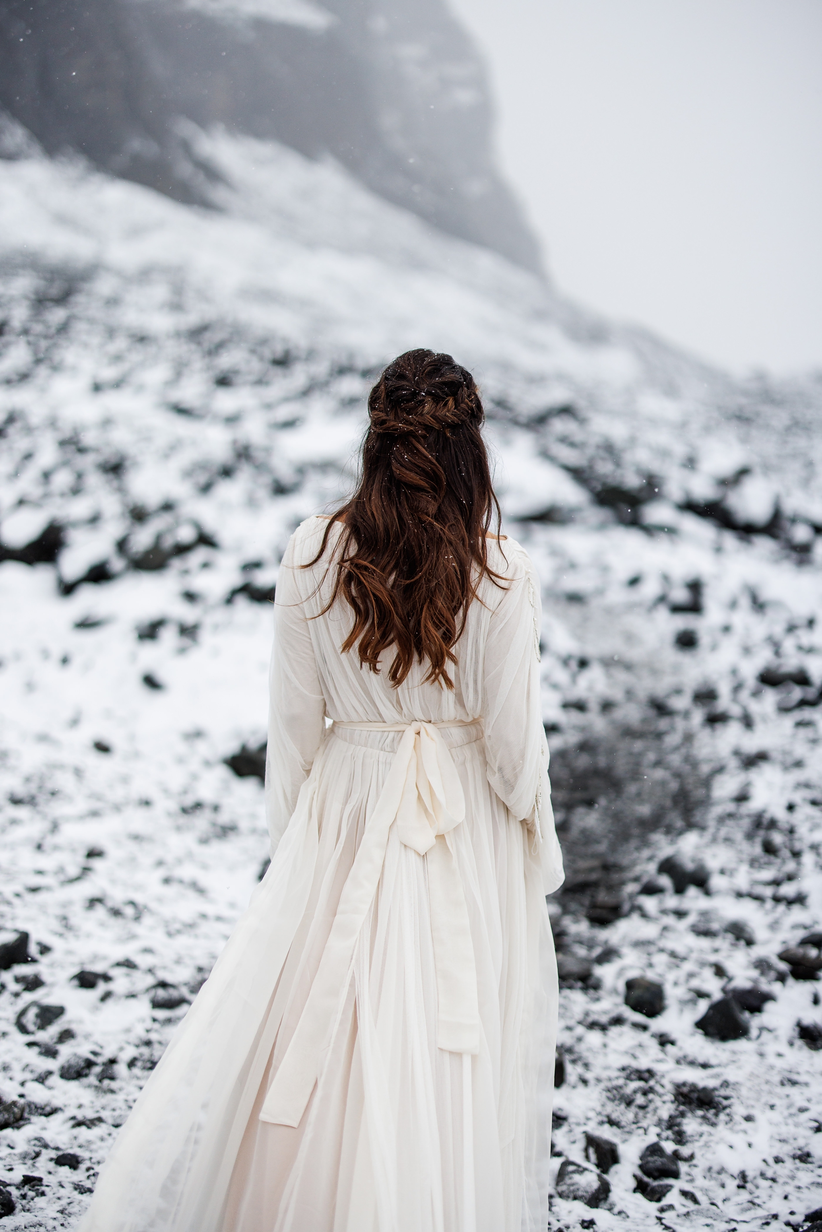 A bride walks into a snowy Narnia landscape in Iceland. 