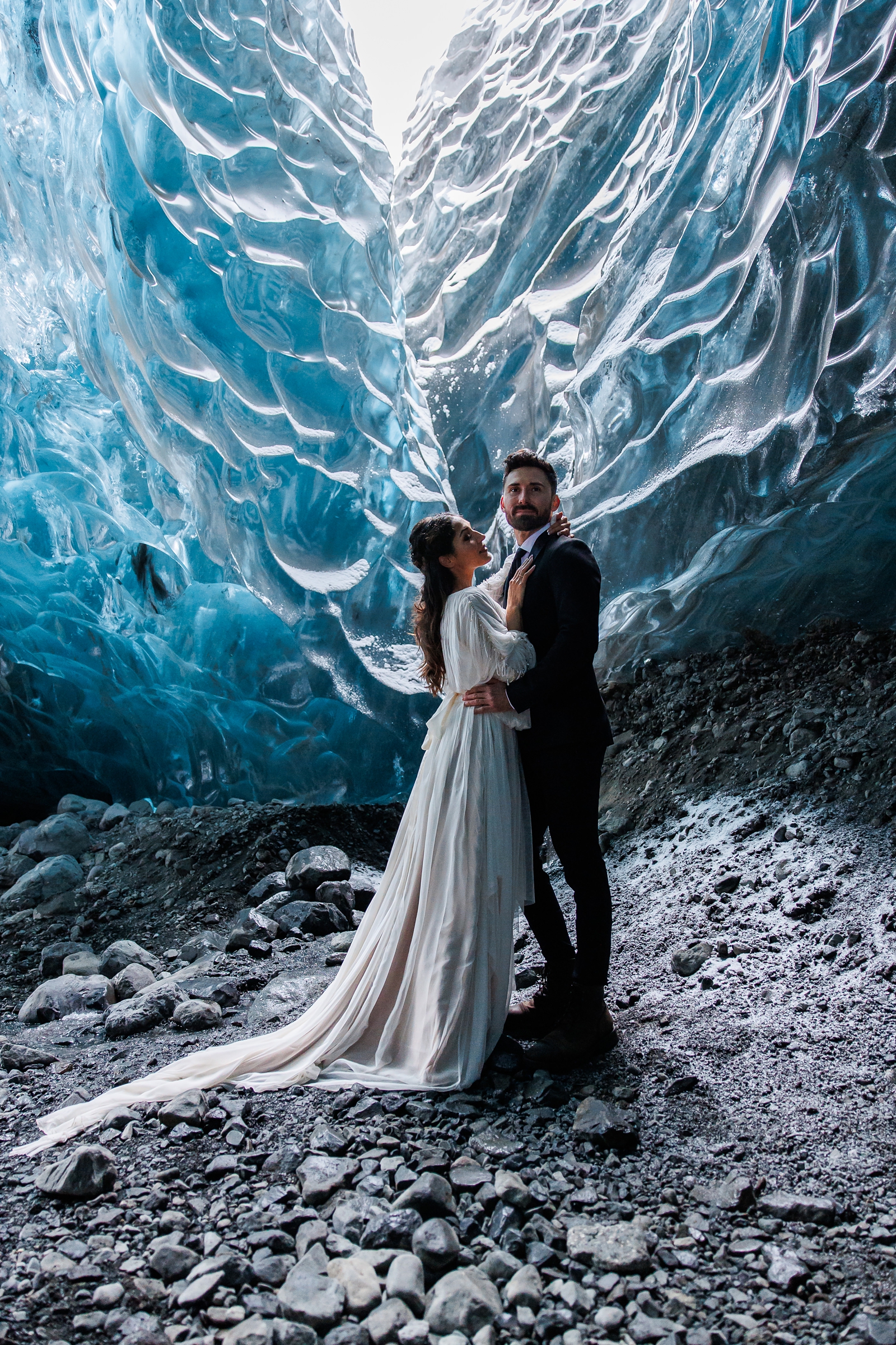 Ice within an ice cave frame an eloping couple in Breiðamerkurjökull Iceland