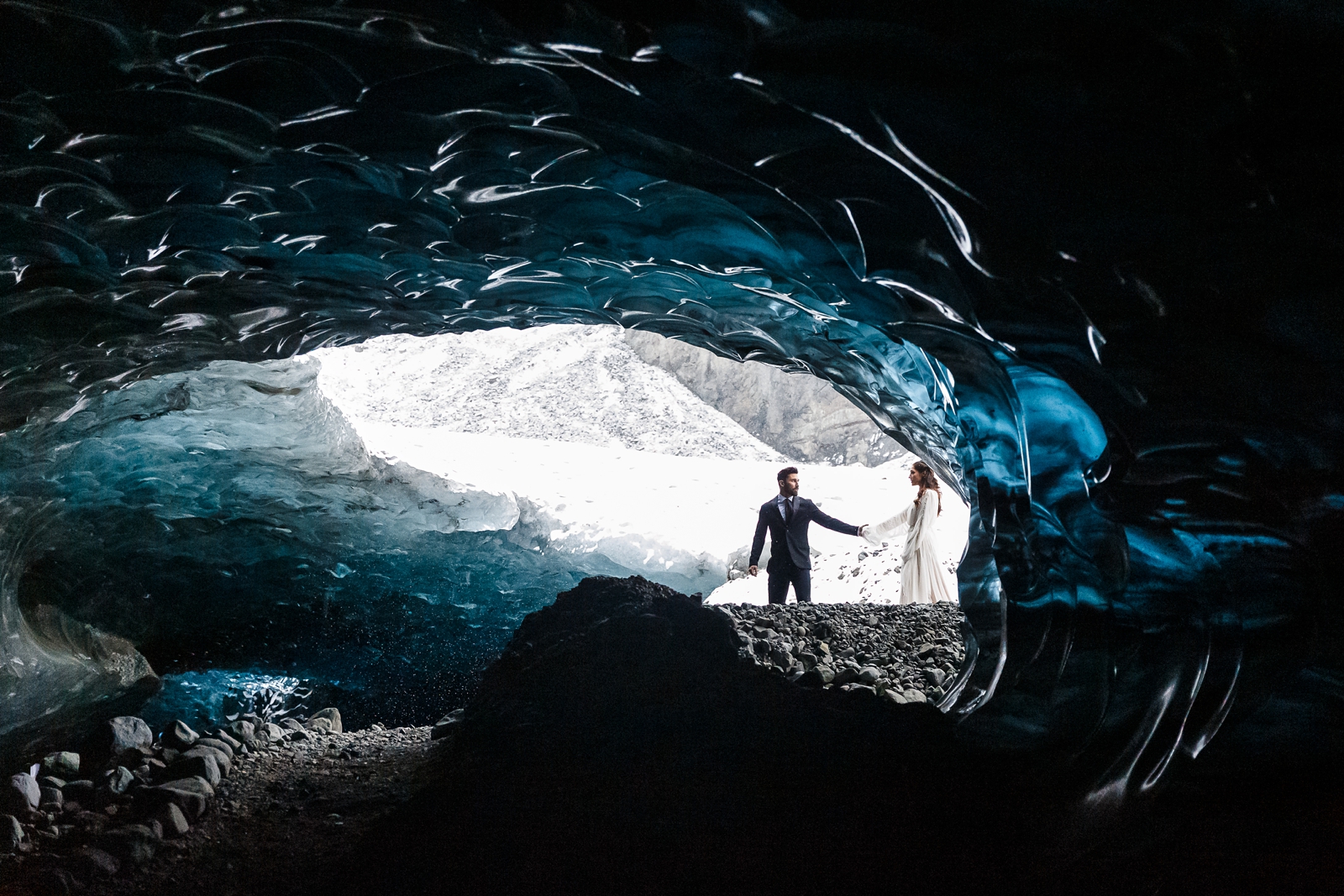 An eloping couple enters their Iceland glacier cave venue.