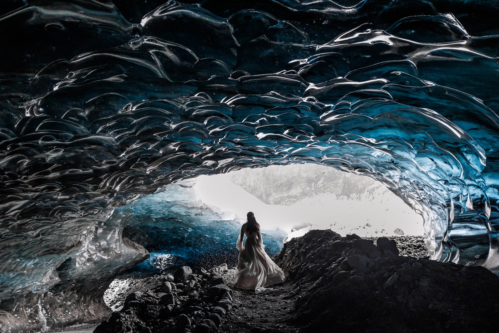 A bride runs through an ice cave on her elopement day in Iceland.