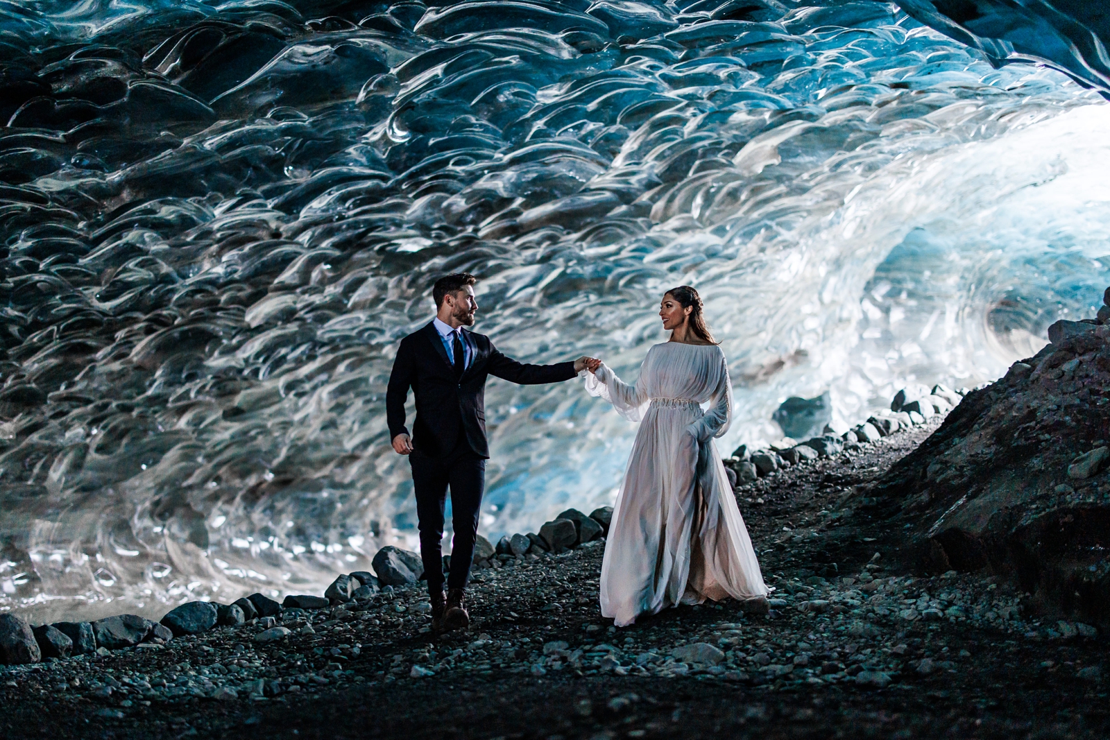 This bride and groom walk in a winter wonderland during their Iceland wedding day.