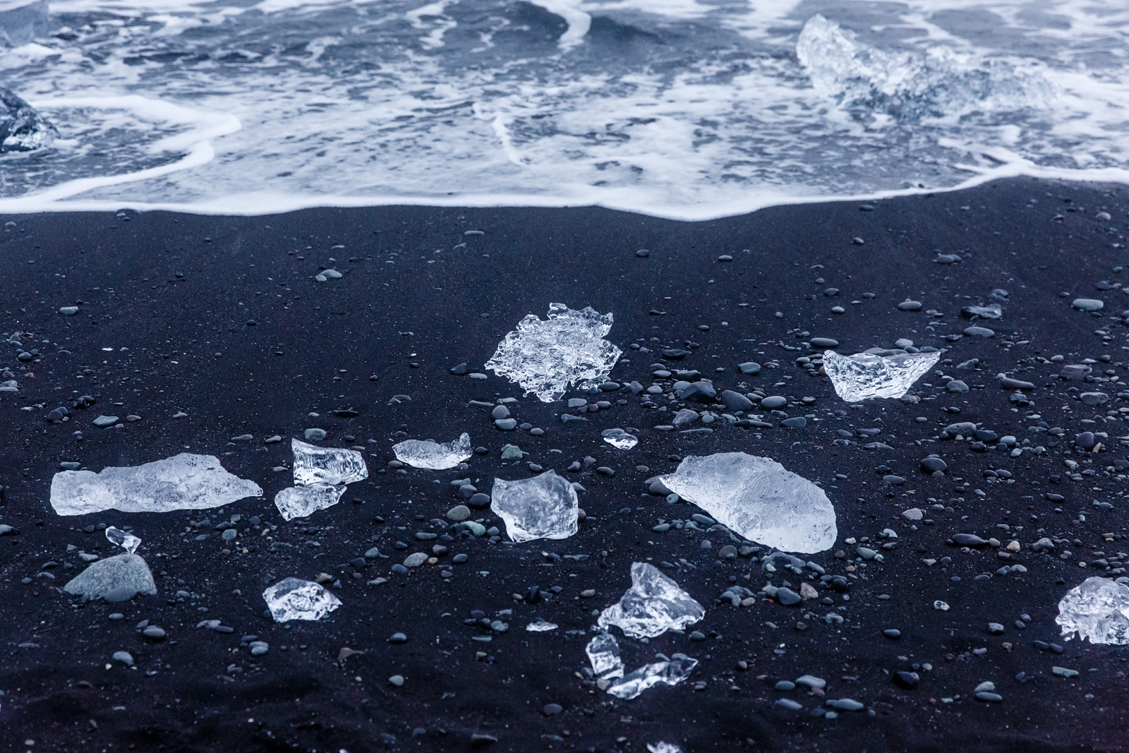 Ice pieces sparkling like diamond's on the black sand of Breiðamerkursandur Beach Iceland.