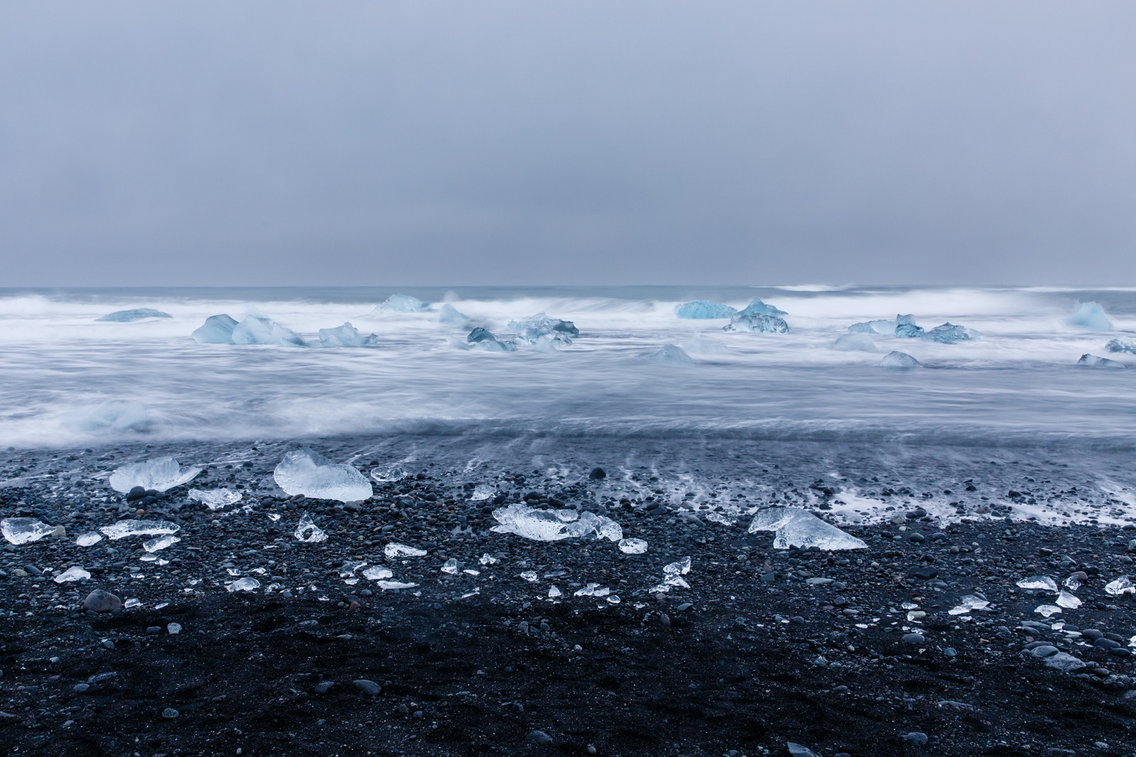 Huge glacier ice pieces in the surf at Diamond Beach Iceland.