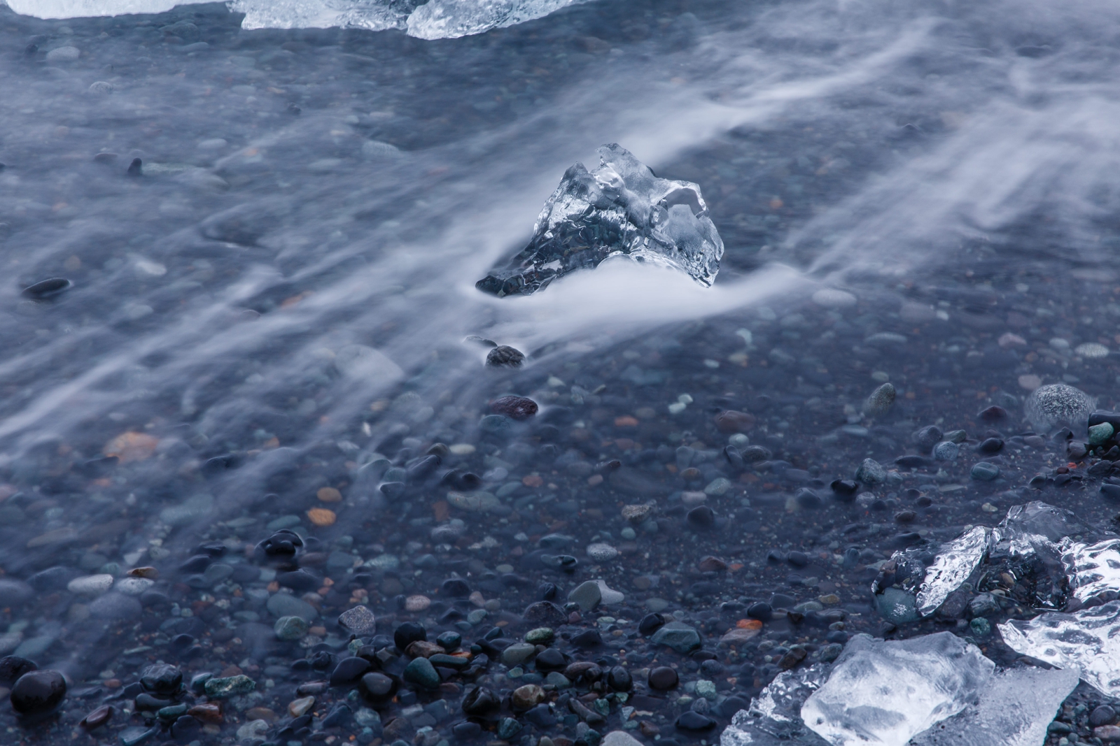 Long exposure of a wave and glacier piece on Diamond Beach Iceland.