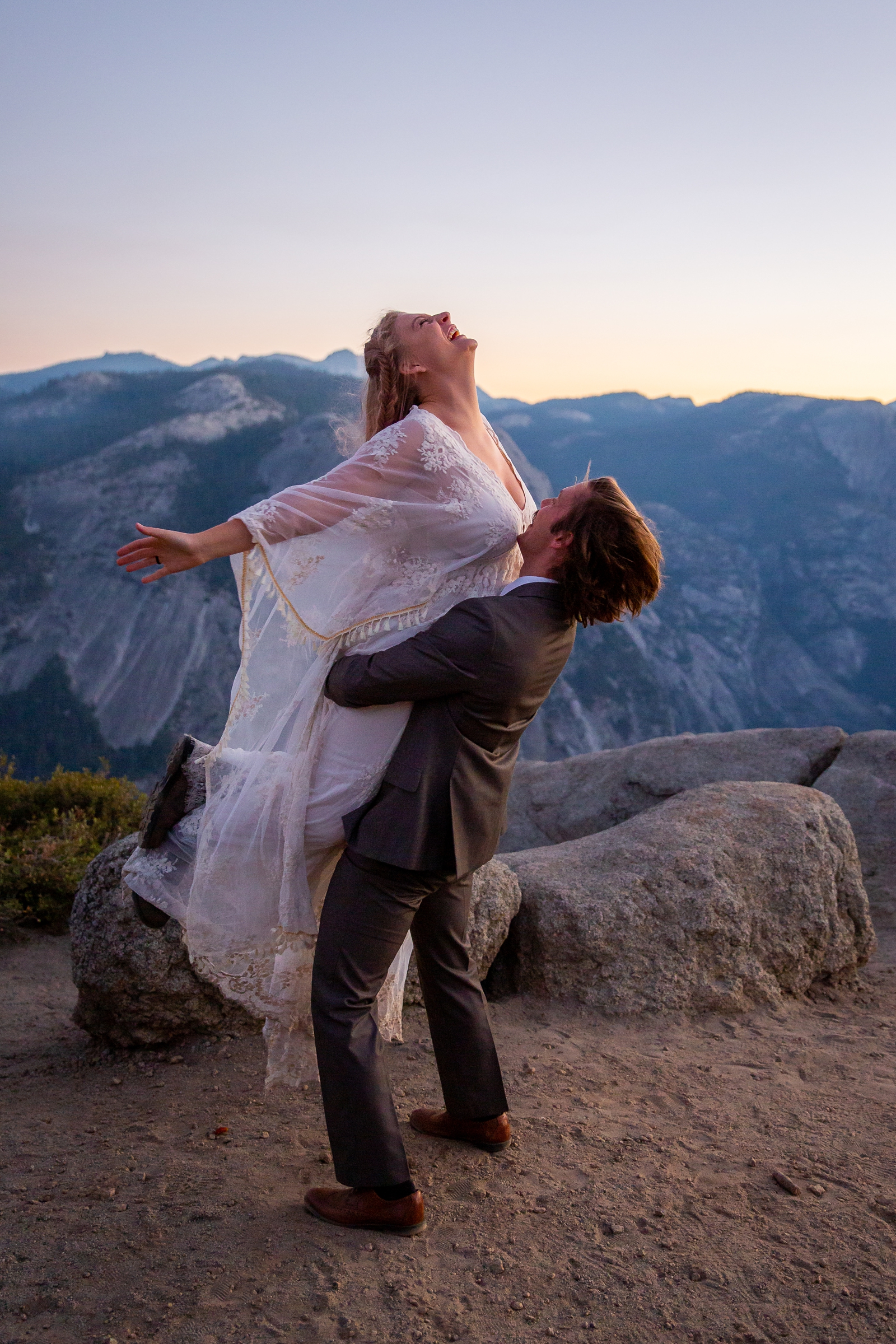 A playful eloping couple at Glacier Point in Yosemite.