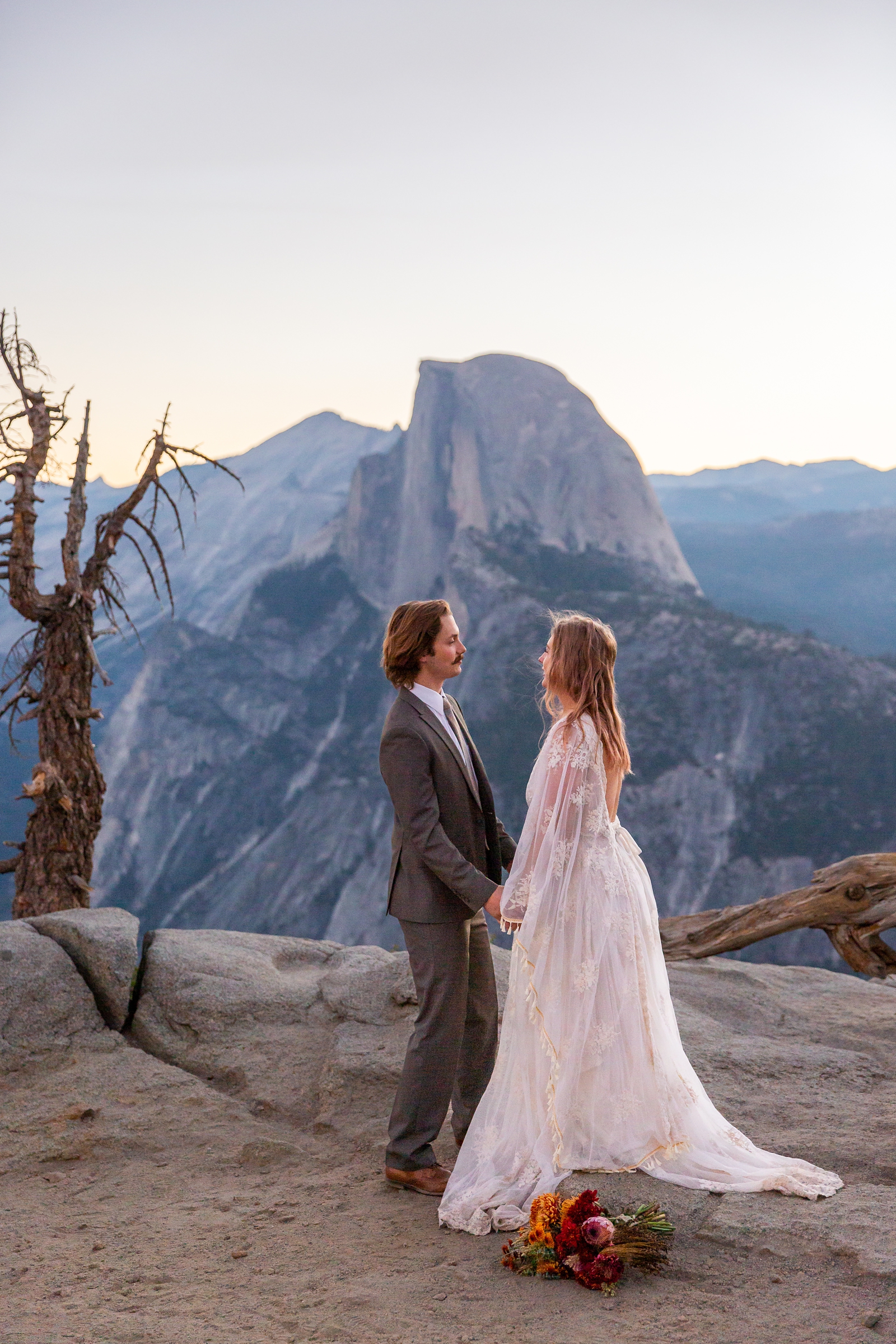 A tender moment at this couple's adventurous Yosemite sunrise Glacier Point elopement.