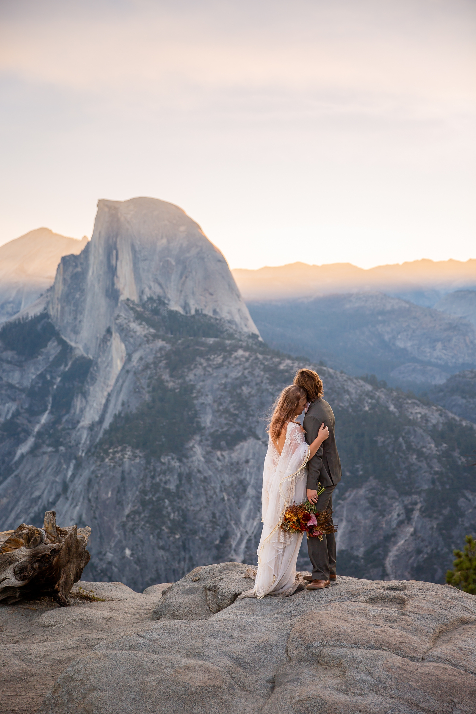 Eloping couple looking at Half Dome at sunrise.