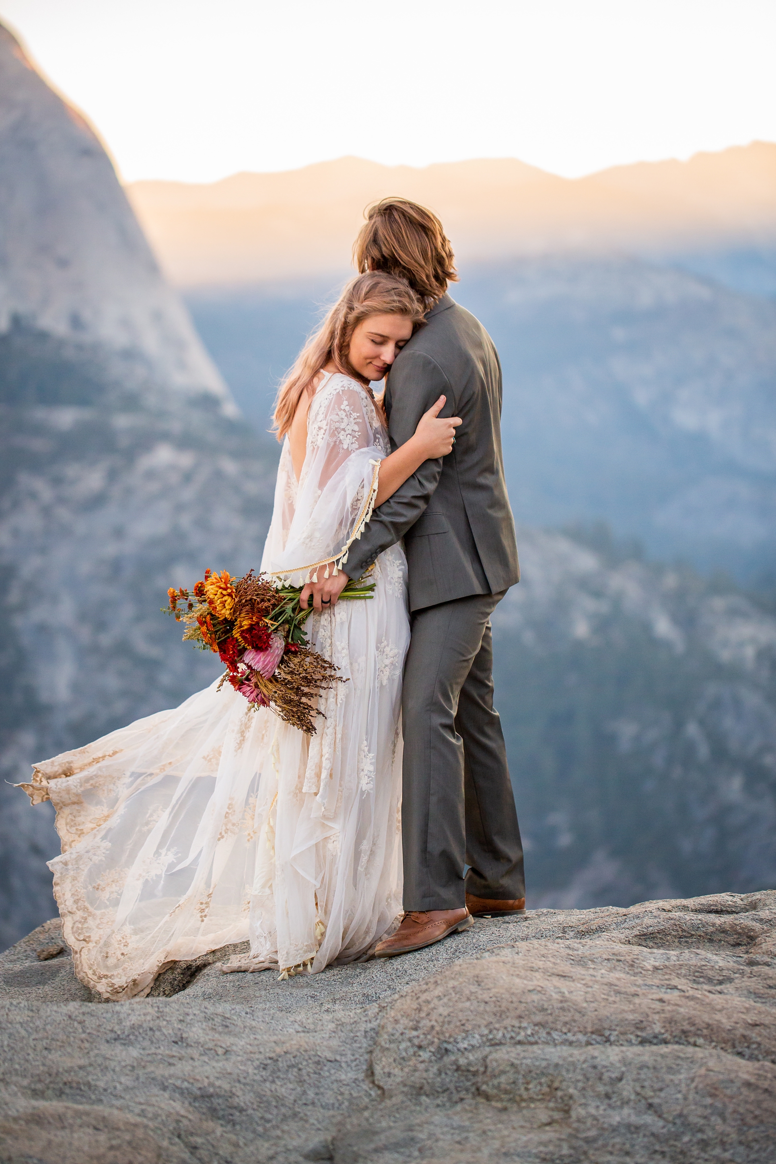 Bride and groom hugging during their sunrise Yosemite Glacier Point elopement.