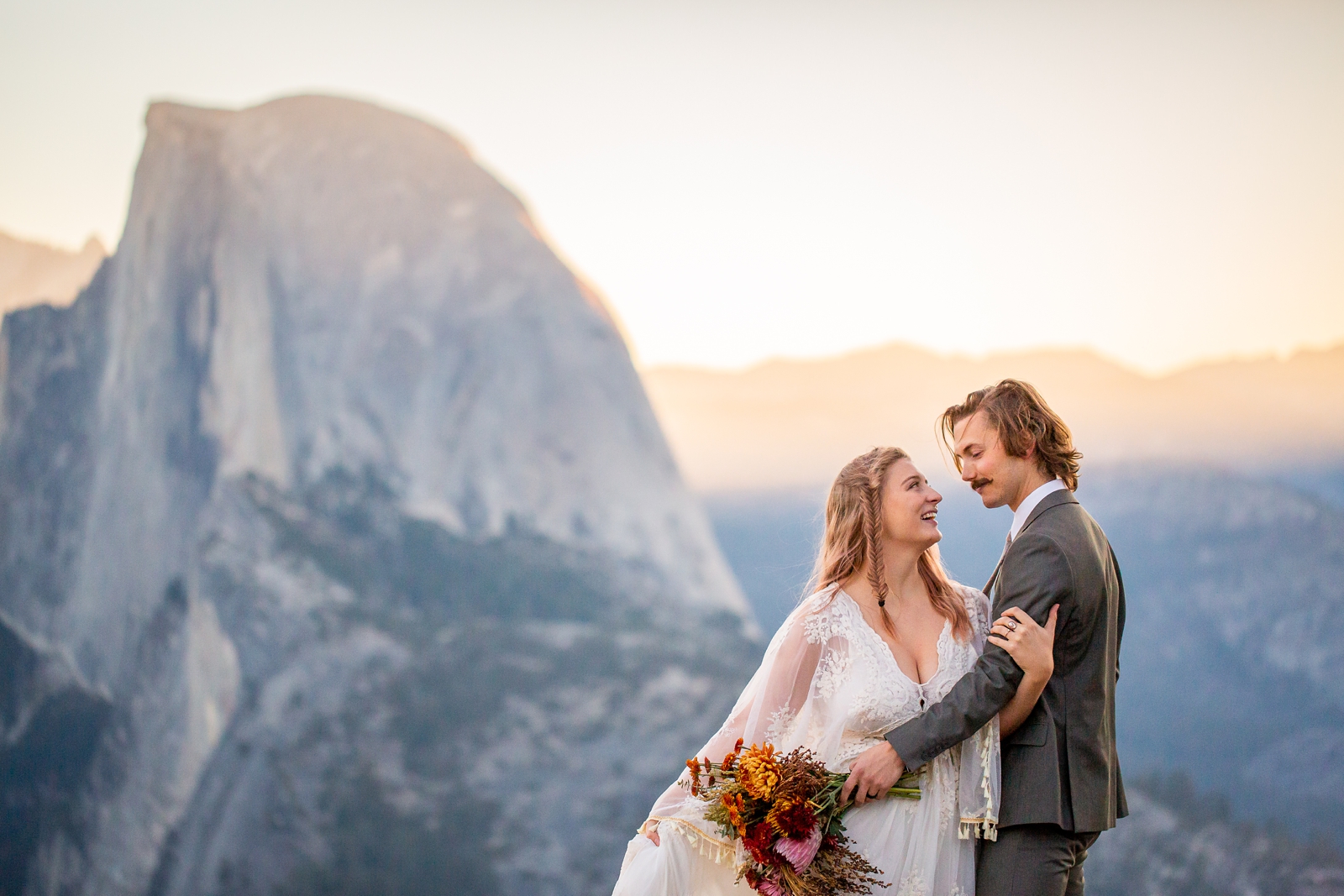 Playful eloping couple in front of Half Dome in Yosemite.