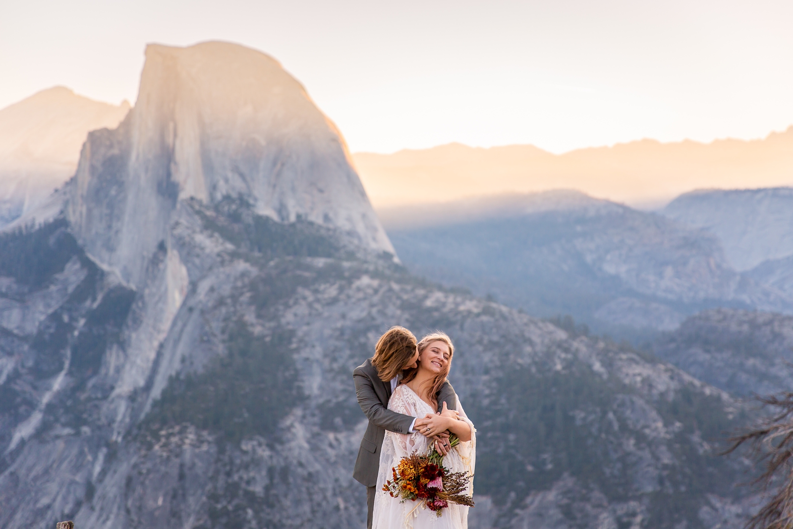 Adorable cuddling couple at their Yosemite sunrise Glacier Point elopement.