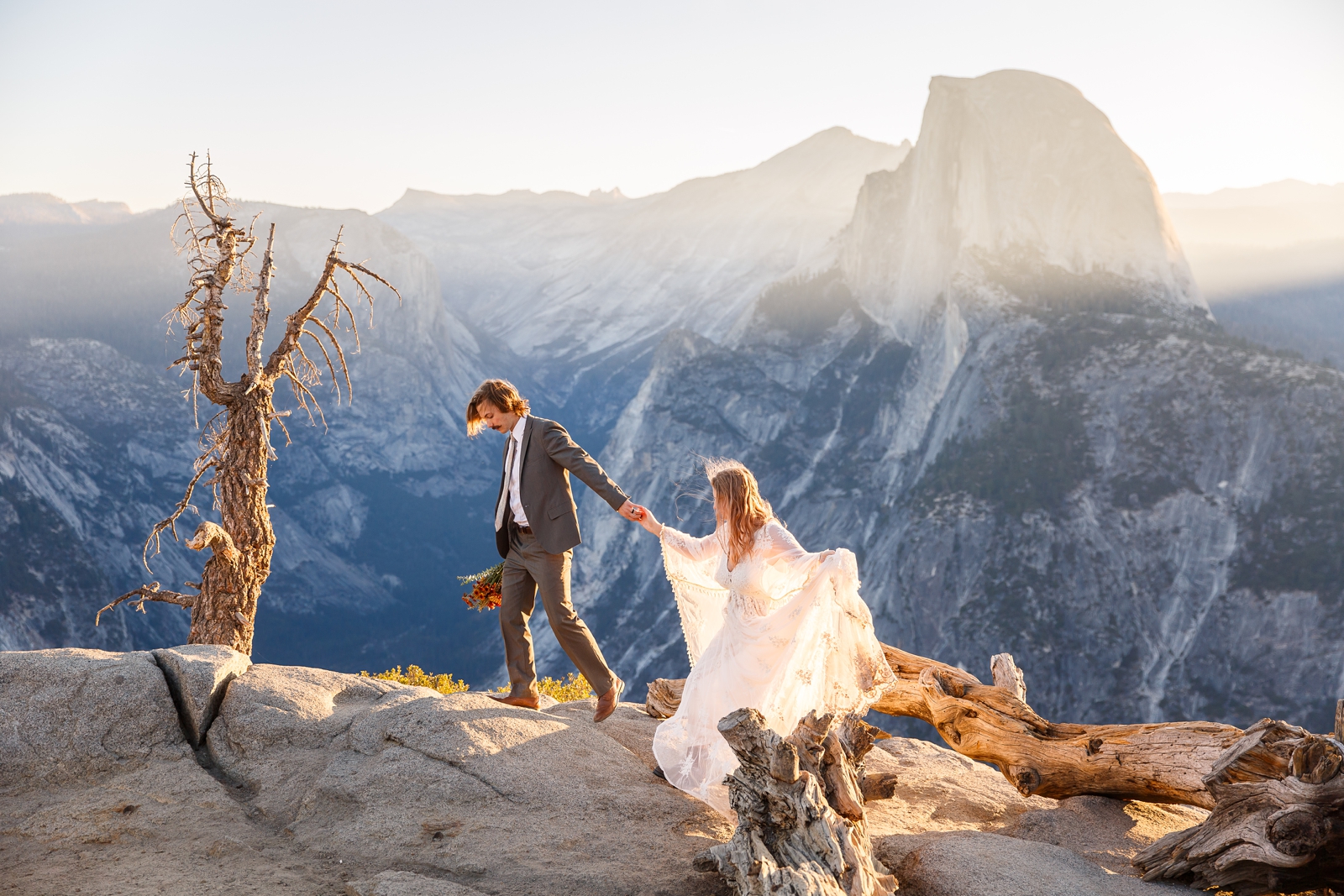 Bride and groom hiking in front of Half Dome in Yosemite.