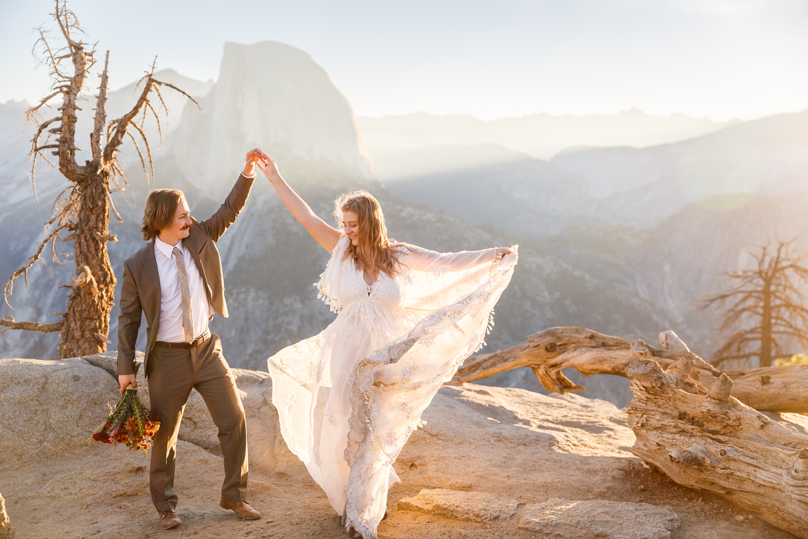 Adventurous eloping couple dancing in front of Half Dome Yosemite at their Glacier Point elopement.