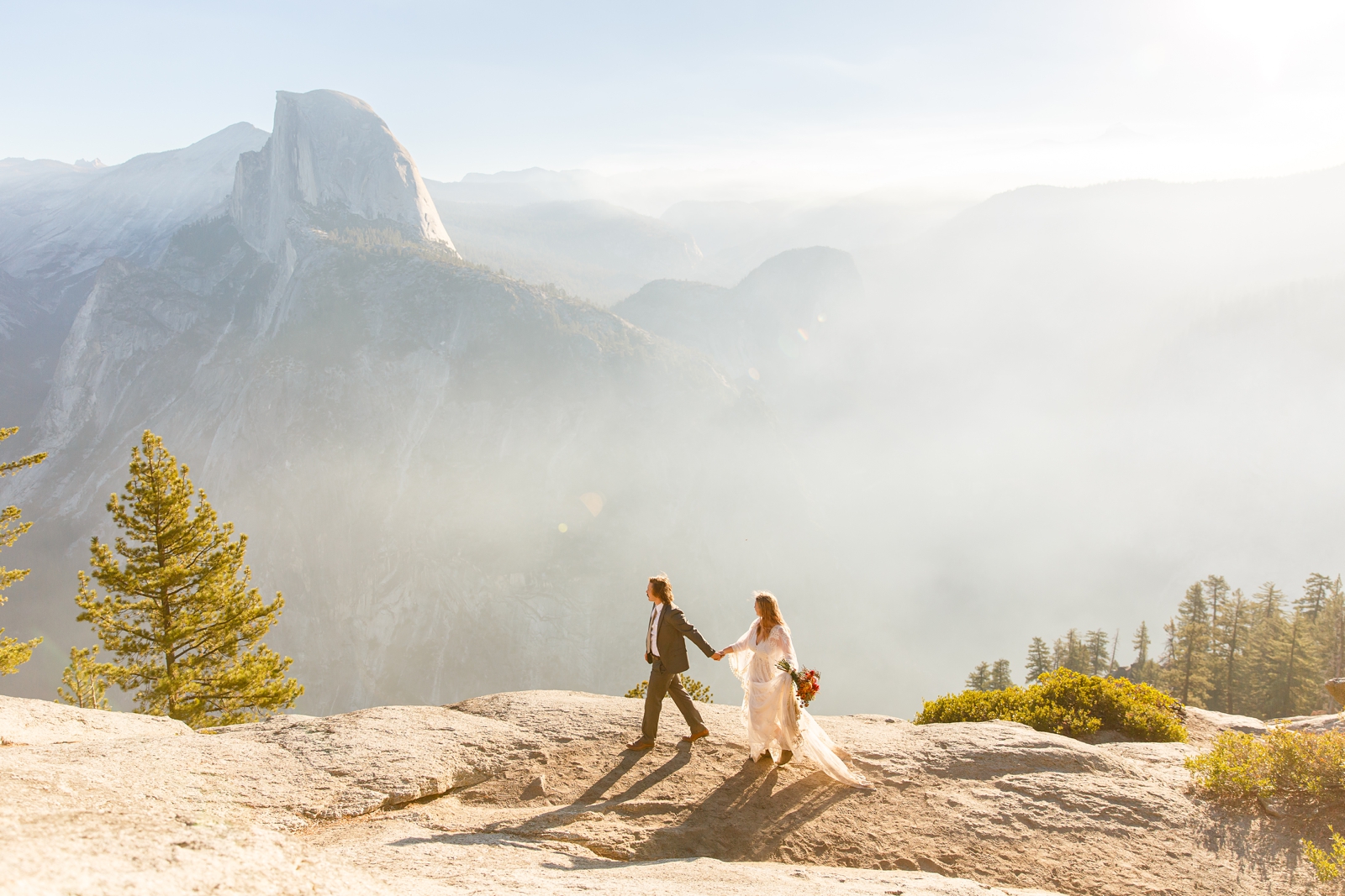 Eloping couple walks on the cliff in Yosemite.